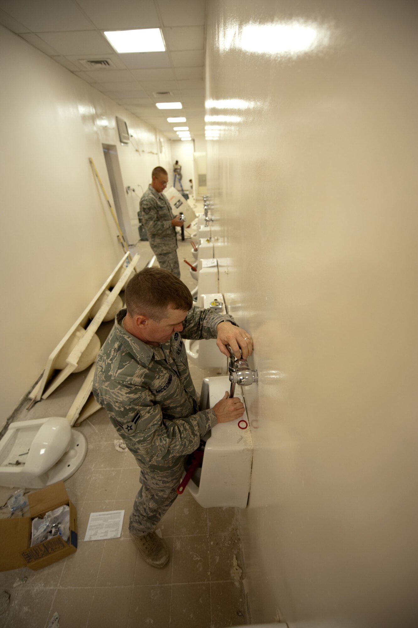 Airman 1st Class James McConnell, 379th Expeditionary Civil Engineer squadron water and fuels system maintenance journeyman, installs plumbing inside a latrine during a renovation project, Oct. 9, 2009 in Southwest Asia. The 379 ECES maintains and upgrades base facilities, when required, to ensure buildings meet Air Force standards. Airman McConnell is deployed from Peterson Air Force Base, Colo., in support of operations Iraqi Freedom and Enduring Freedom. (U.S. Air Force photo/Staff Sgt. Robert Barney) 