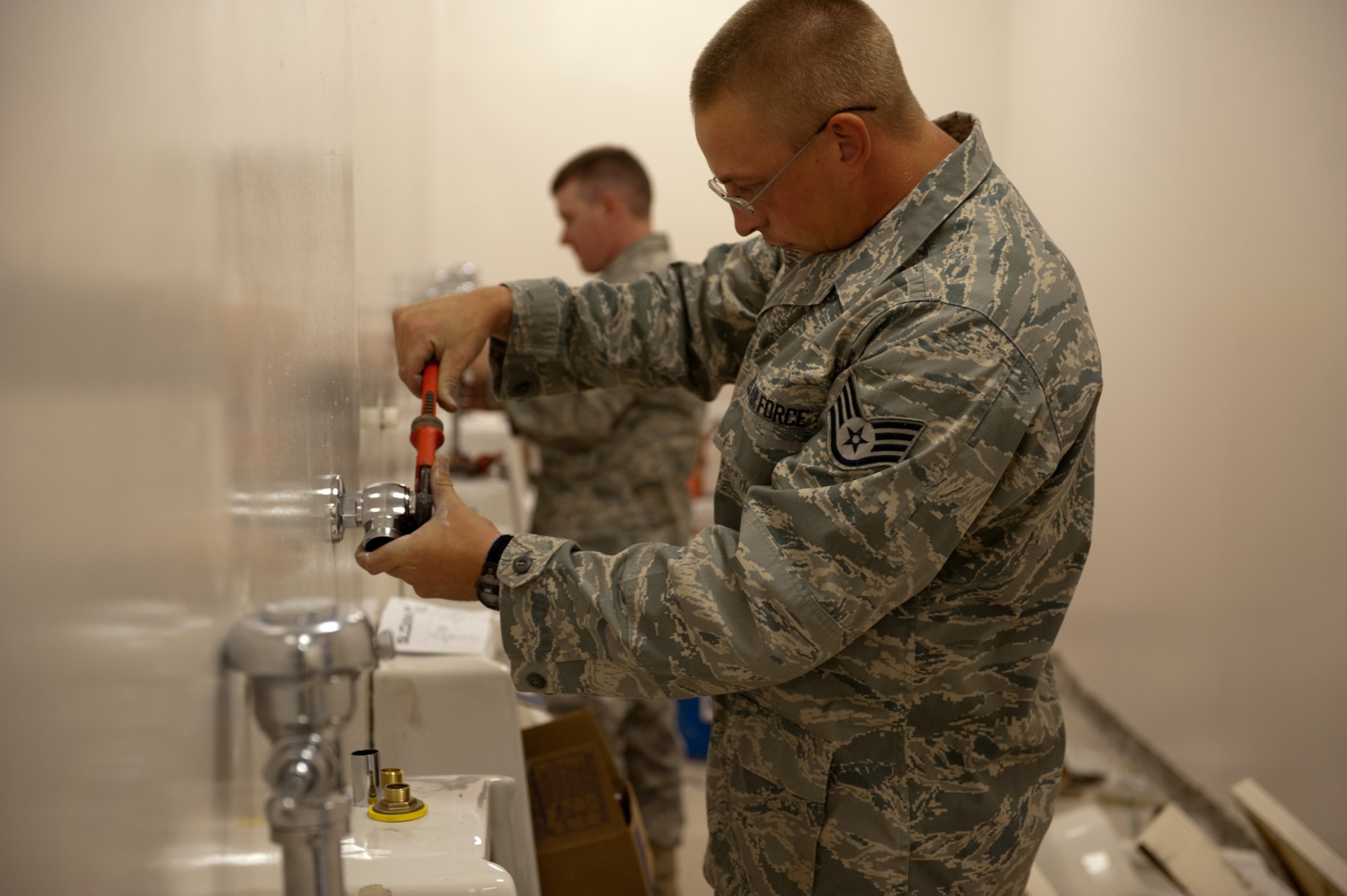 Staff Sgt. Nicholas Nenichka, 379th Expeditionary Civil Engineer squadron water and fuels system maintenance craftsman, installs plumbing inside a latrine during a renovation project, Oct. 9, 2009, in Southwest Asia. The 379 ECES maintains and upgrades base facilities, when required, to ensure buildings meet Air Force standards. Sergeant Nenichka is deployed from Patrick Air Force Base, Fla., in support of operations Iraqi Freedom and Enduring Freedom. (U.S. Air Force photo/Staff Sgt. Robert Barney) 