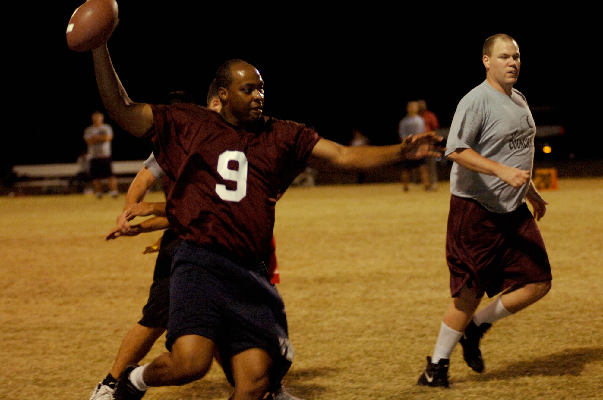LANGLEY AIR FORCE BASE, Va. -- Air Combat Command/A8 quarterback Etienne Menard evades tackles along the sideline during a flag football game here Oct. 8. Menard's potent offensive production led the ACC/A8 team to a 25-6 victory over the 497th Intelligence, Surveillance, and Reconnaissance Group team. (U.S. Air Force photo/Airman 1st Class Jason J. Brown)