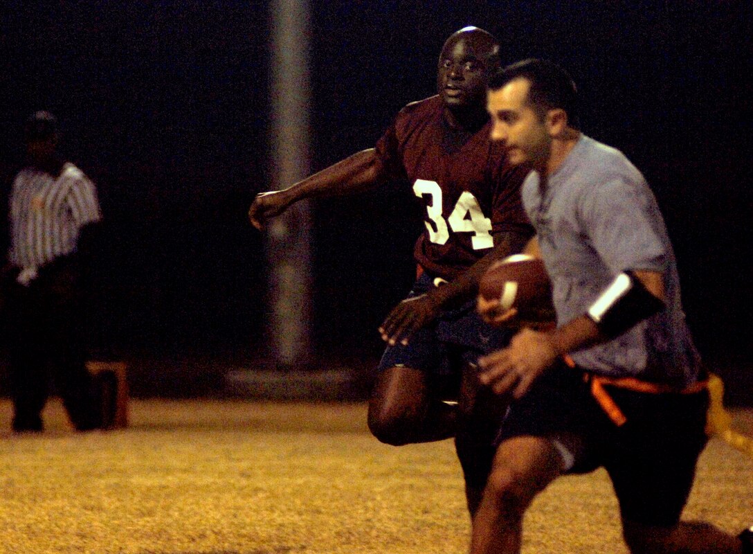 LANGLEY AIR FORCE BASE, Va. -- Air Combat Command/A8 lineman Ken "Dog Slobber" Carmichael rushes the 497th Intelligence, Surveillance, and Reconnaissance Group team's quarterback in a flag football game here Oct. 8. The pass rush on the 497th ISRG team limited their offensive production, resulting in a 25-6 loss to the ACC/A8 team. (U.S. Air Force photo/Airman 1st Class Jason J. Brown)