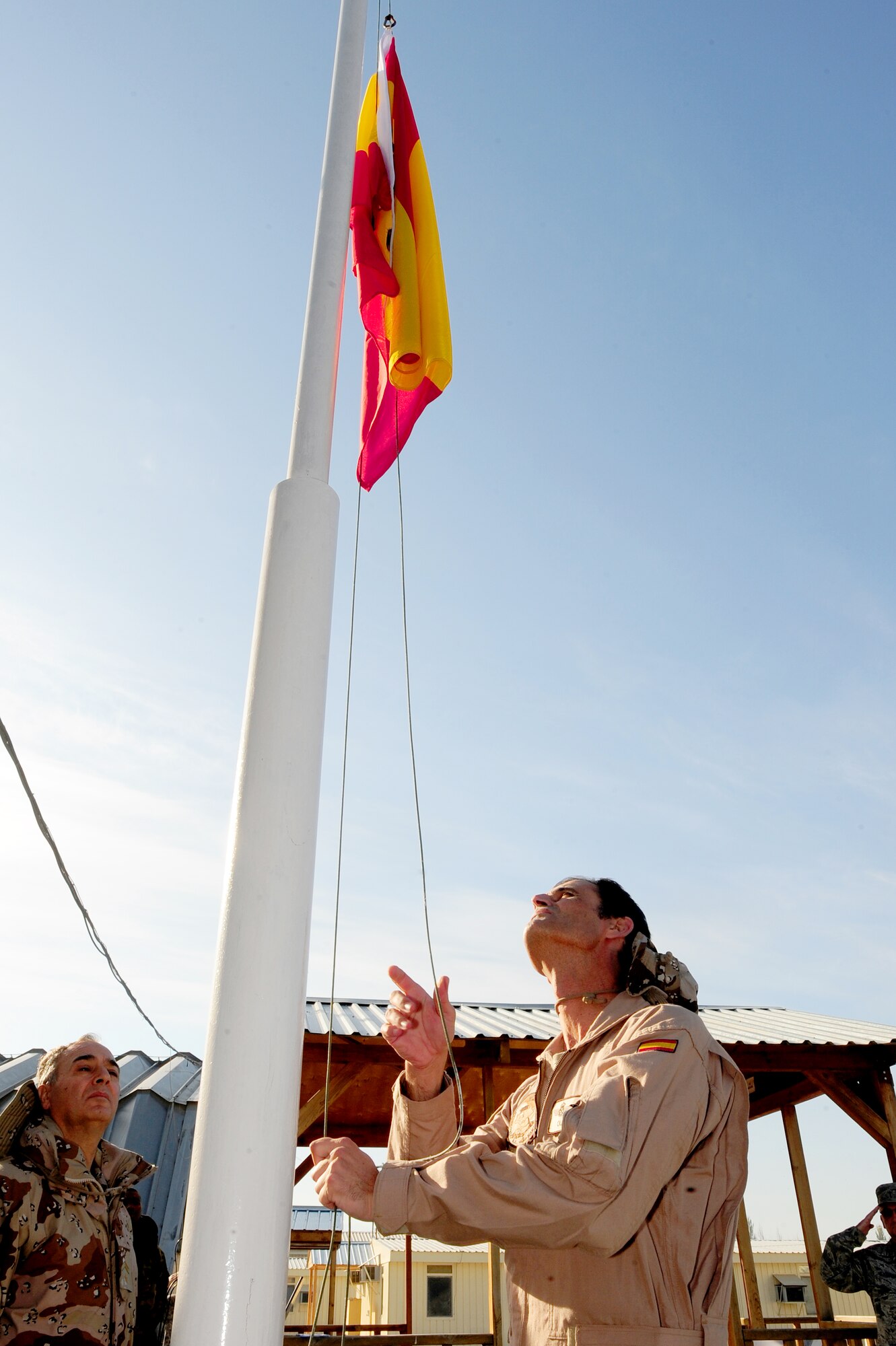 TRANSIT CENTER AT MANAS, Kyrgyzstan -- Maj. Miguel Oliver, Spanish Air Force Mizar Detachment commander, lowers the Spanish flag signifying a halt in operations at the Transit Center, Oct. 5, 2009. The Spanish Mizar Detachment marked the end of a tour at the Transit Center by honoring those who have made the ultimate sacrifice in support of operation ENDURING FREEDOM. (U.S. Air Force photo/Senior Airman Steele C. G. Britton)