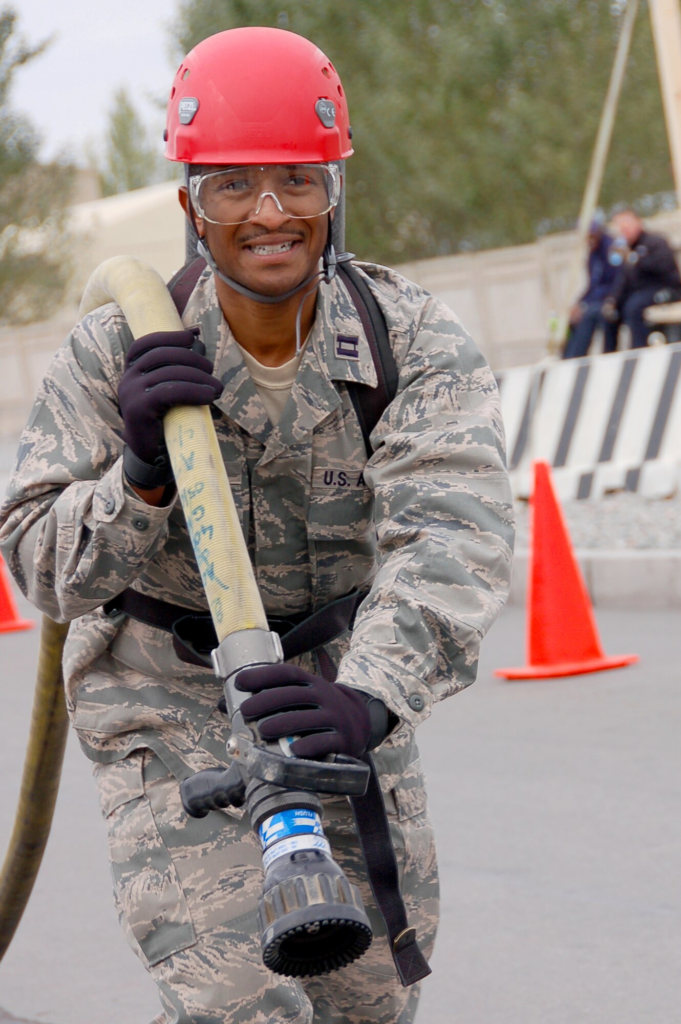 TRANSIT CENTER AT MANAS, Kyrgyzstan -- Capt. Deshawn Jones, 376th Expeditionary Mission Support Group executive officer, performs hose advancement drills as part of the Fire Fighter Challenge at the Transit Center, Oct. 10, 2009. A total of eight teams participated in the race against the clock, ending in a result of a 376th Expeditionary Security Forces Squadron team victory. (U.S. Air Force photo/Staff Sgt. Olufemi Owolabi)