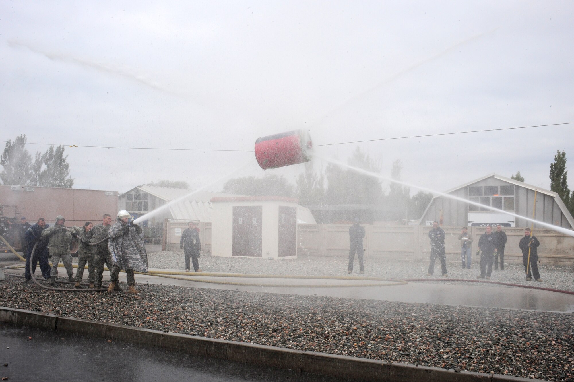 TRANSIT CENTER AT MANAS, Kyrgyzstan -- Two teams battle it out for the second-place prize following a Fire Fighter Challenge at the Transit Center during Fire Prevention Week, Oct. 10, 2009. Top teams had to test their hose capabilities by knocking the barrel to the opponent's side. The competition brought a very successful Fire Prevention Week to an end at Manas. (U.S. Air Force photo/Senior Airman Steele C. G. Britton)