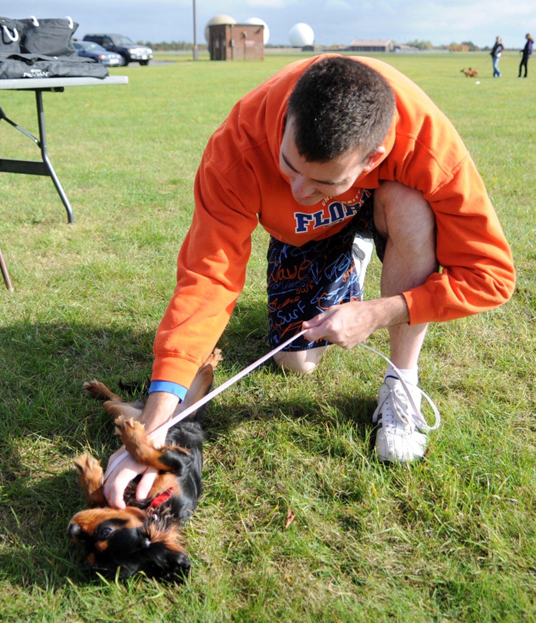 RAF FELTWELL, England -- Senior Airman Daniel Guck, 48th Aircraft Maintenance Squadron, RAF Lakenheath, pets his dog Duchess at the RAF Feltwell Vet Clinic's 2nd Annual Petfest Oct. 12.  More than 100 pet owners showed up with their furry friends - many in costume - for the event, which helped raise money for a local cat charity.  (U.S. Air Force photo/Staff Sgt. Austin M. May)