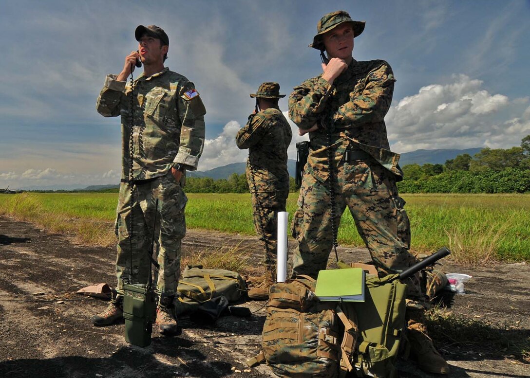 PADANG, Indonesia --  A U.S. Air Force combat controller from the 320th Special Tactics Squadron at Kadena Air Base, Japan, (left) and two U.S. Marines relay air traffic control information to incoming U.S. aircraft landing at Tangbing Airfield here Oct. 9. The airfield's ATC tower was severely damaged during the Sept. 30 earthquake which struck here, effectively stopping the flow of aircraft. Combat controllers and Marines continue to provide ATC capabilities to allow U.S., Australian and Indonesian aircraft to transfer humanitarian supplies into the region. (U.S. Air Force photo/Staff Sgt. Veronica Pierce)