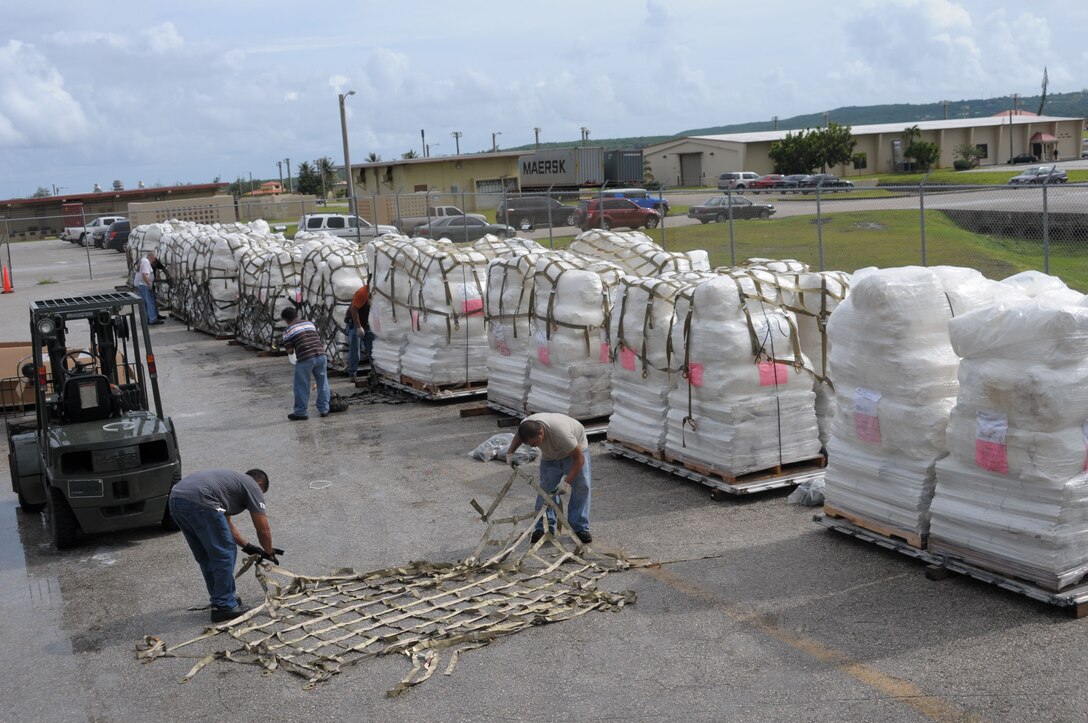 Contractors for DZSP 21 palletize FEMA tents Oct. 9 at Andersen Air Force Base, Guam, for delivery to American Samoa after the area was struck by an earthquake and resulting tsunami. A total of 13 pallets containing 800 tents will be flown from Guam by an Air Force C-17 Globemaster III in support of FEMA's humanitarian aid mission. (U.S. Air Force photo by Master Sgt. Carrie Hinson) 
