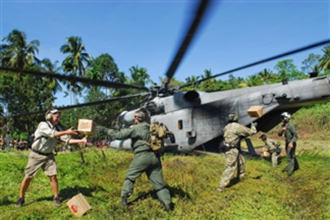 U.S. airmen and Marines unload relief supplies from a CH-53E Super Stallion helicopter assigned to Marine Medium Helicopter Squadron 265 in Padang, West Sumatra, Indonesia, on Oct. 9, 2009.  The supplies were delivered after two earthquakes ravaged the region.  The U.S. Navy's Amphibious Force 7th Fleet is directing the U.S. military response to a request from the Indonesian government for assistance and support for humanitarian efforts.  