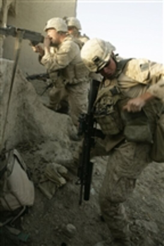 A U.S. Marine with 2nd Battalion, 8th Marine Regiment reaches for more rounds during an attack at Patrol Base Bracha in the Garmsir district of Helmand province, Afghanistan, on Oct. 9, 2009.  The Marines are deployed with Regimental Combat Team 3, whose mission is to conduct counterinsurgency operations in partnership with Afghan security forces in southern Afghanistan.  