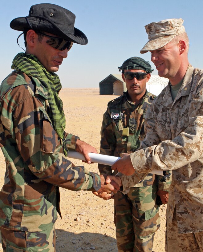 Maj. Christopher Wills, commanding officer of Kilo Company, Battalion Landing Team, 3rd Battalion, 2nd Marine Regiment, 22nd Marine Expeditionary Unit, presents battle maps of Iwo Jima to a Jordanian commando during Exercise Bright Star 2009 in Egypt, Oct. 13, 2009. The multinational exercise is designed to improve readiness, interoperability, and strengthen the military and professional relationships among U.S., Egyptian and participating forces. Bright Star is conducted by U.S. Central Command and held every two years. Elements of the 22nd MEU are currently are participating in the multi-national exercise while serving as the theater reserve force for U.S. Central Command.::r::::n::(Official Marine Corps Photo by Lance Cpl. David Castillo)::r::::n::