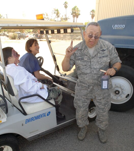 Senior Master Sgt. Clayton Cortinas jokes as he creates fake injuries on the two ‘victims.’ The drill simulated a collision between a golf cart and a semi-truck and was the second of two Aerospace Medicine Squadron exercises. (U.S. Air Force photo by Maj. David Sell)