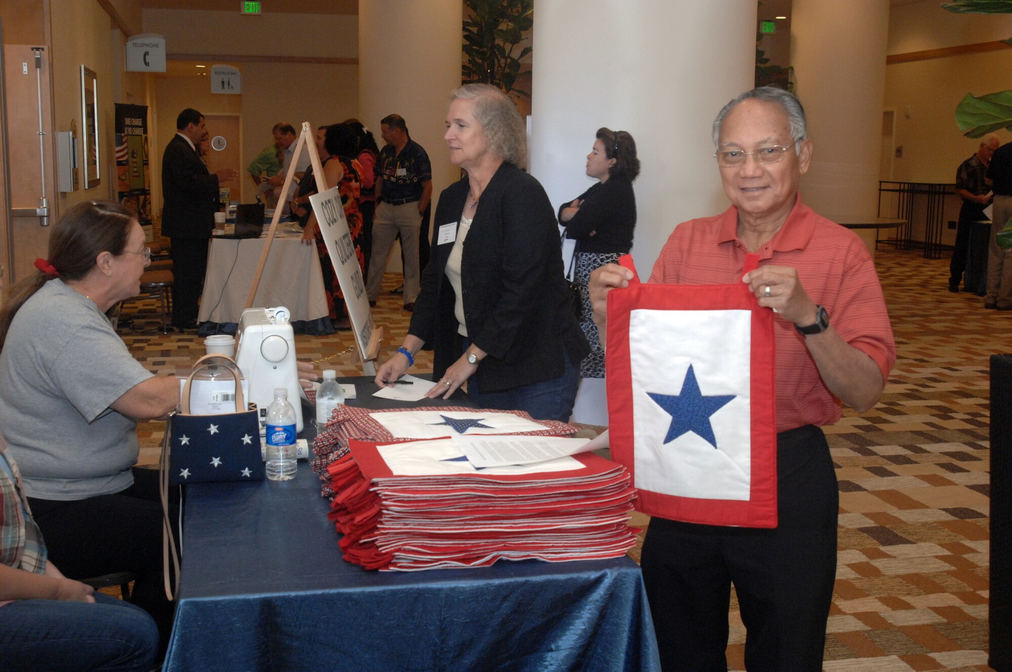 A Yellow Ribbon Reintegration Program participant holds a hand-sewn Blue Star banner he was given during last weekend’s event held in the San Diego Bayfront Hilton Hotel. This service flag is an official banner authorized by the Department of Defense for display by families who have members serving in the U.S. Armed Forces during any period of war or hostilities. The free banners were given to parents, spouses and children to display in their home’s window. The Blue Star Banner booth was one of about a dozen vendors who supported the program. (U.S. Air Force photo by Tech. Sgt. Michele Desrochers)