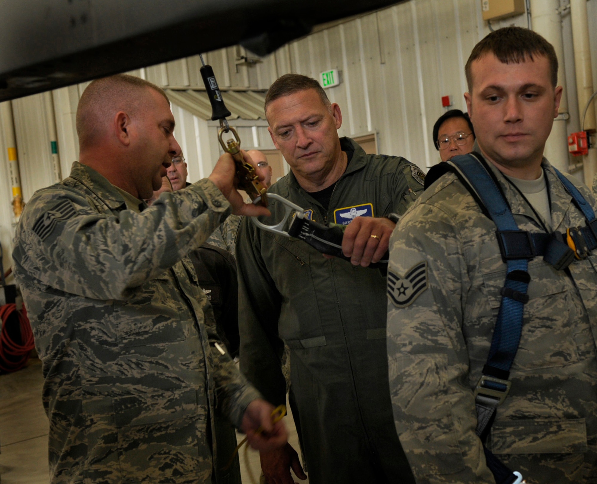 Tech. Sgt. Edward Hutcherson briefs Pacific Air Forces Commander Gen. Gary North about a safety harness being demonstrated by Staff Sgt. Travis McKee while touring Eielson Air Force Base, Alaska, Oct. 2, 2009.  The harness is part of a restraint system to increase safety while performing aircraft maintenance. (U.S. Air Force photo/Airman 1st Class Laura Goodgame)