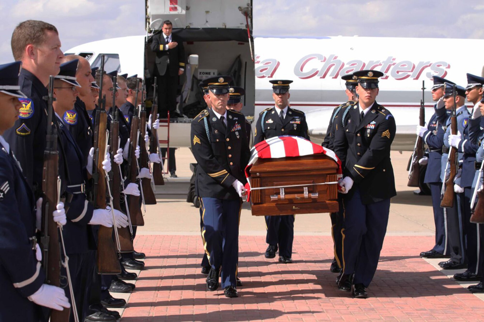 A combined Luke Air Force Base and Phoenix Police Department Honor Guard present arms as Army pallbearers carry Arizona National Guard Staff Sgt. Thomas Rabjohn after his return home Oct. 12. Staff Sgt. Rabjohn served as an Army explosive ordnance disposal technician and was also a Phoenix police officer.  He was killed while disarming an improvised explosive device in Afghanistan.  (Phoenix PD/Courtesy Photo)