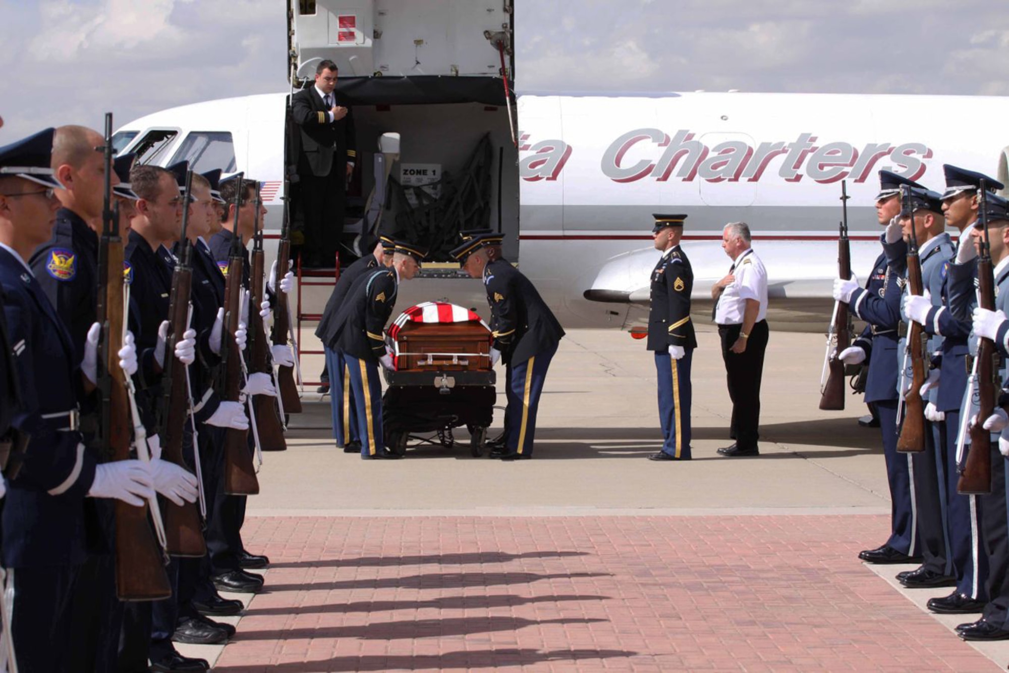 A combined Luke Air Force Base and Phoenix Police Department Honor Guard present arms as Army pallbearers receive the casket of Arizona National Guard Staff Sgt. Thomas Rabjohn Oct. 12 on the base flight line.  Staff Sgt. Rabjohn was an explosive ordnance disposal technician and member of the Phoenix PD.  (Phoenix PD/Courtesy Photo)