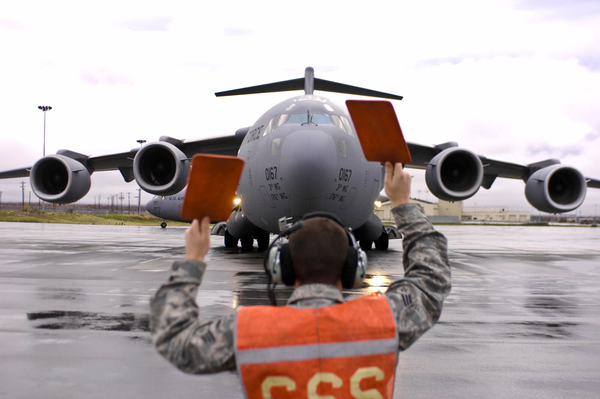 ELMENDORF AIR FORCE BASE, Alaska -- Senior Airman Edward Henry, 517th Aircraft Maintenance Unit, directs a C-17 Globemaster III as it taxis in after landing Oct. 8 during Red Flag-Alaska 10-01. Red Flag-Alaska is a Pacific Air Forces directed field training exercise for U.S. forces, flown under simulated air combat conditions. It is conducted on the Joint Pacific Alaskan Range Complex with air operations flown out of Eielson and Elmendorf Air Force bases. (U.S. Air Force photo/Airman 1st Class Christopher Gross)