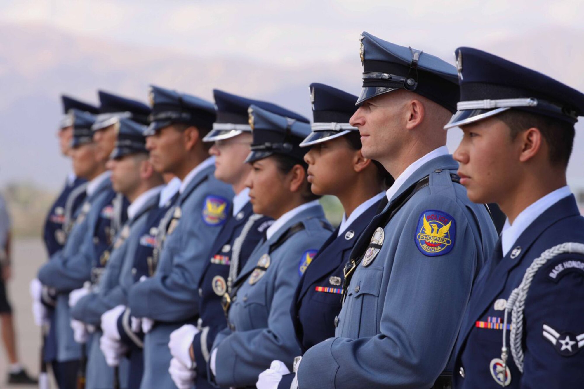Honor guard members from the Luke Air Force Base and the Phoenix Police Department stand side-by-side Oct. 12 prior to the arrival of a commercial aircraft carrying Arizona Army National Guard Staff Sgt. Thomas Rabjohn who was killed in Afghanistan while disarming an improvise explosive device.  (Phoenix PD/Courtesy Photo)