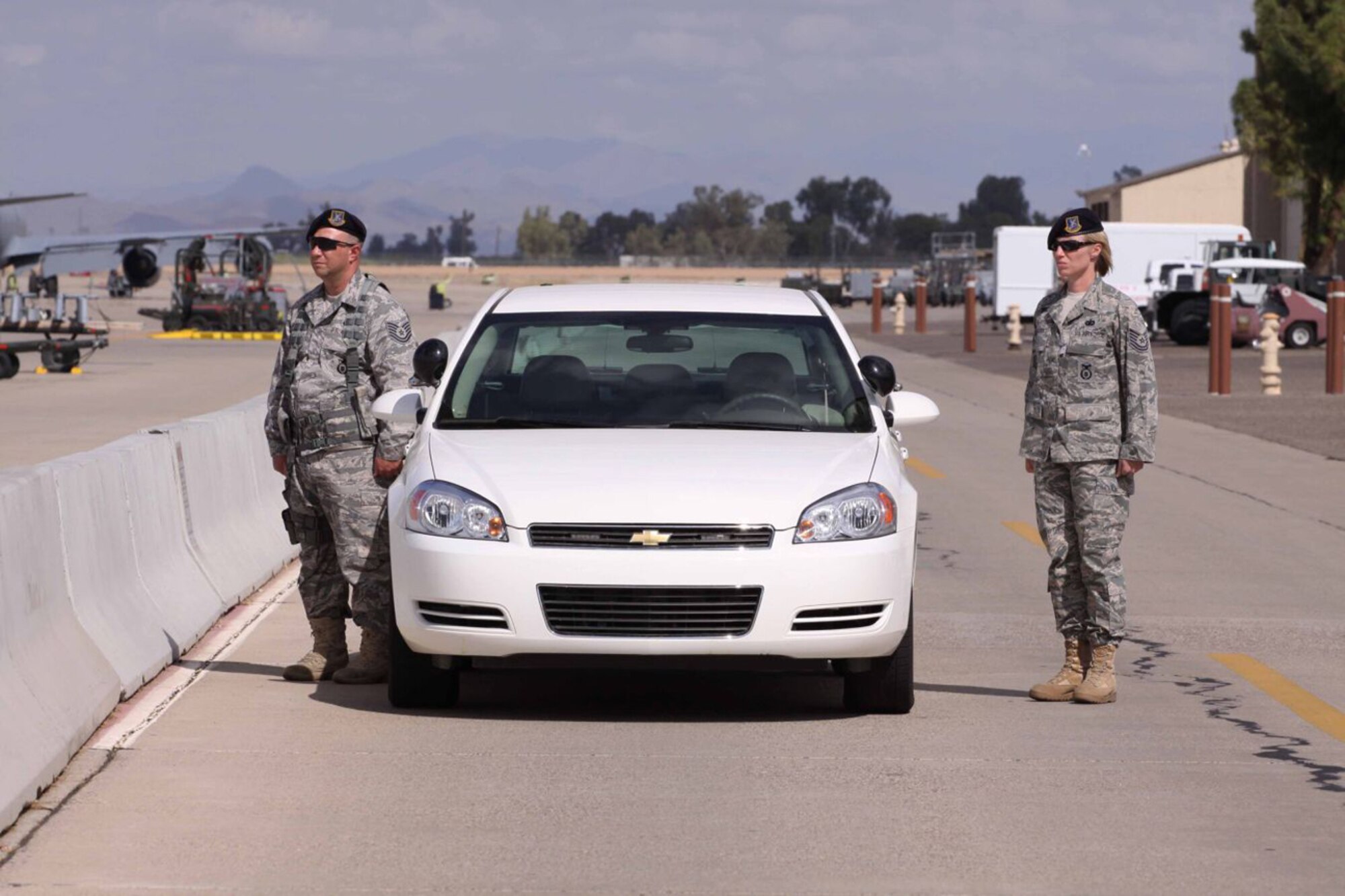 A Luke Air Force Base security forces patrol stands at attention outside the base flight line Oct. 12 during the arrival of a commercial aircraft carrying Arizona Army National Guard Staff Sgt. Thomas Rabjohn.  (Phoenix PD/Courtesy Photo)