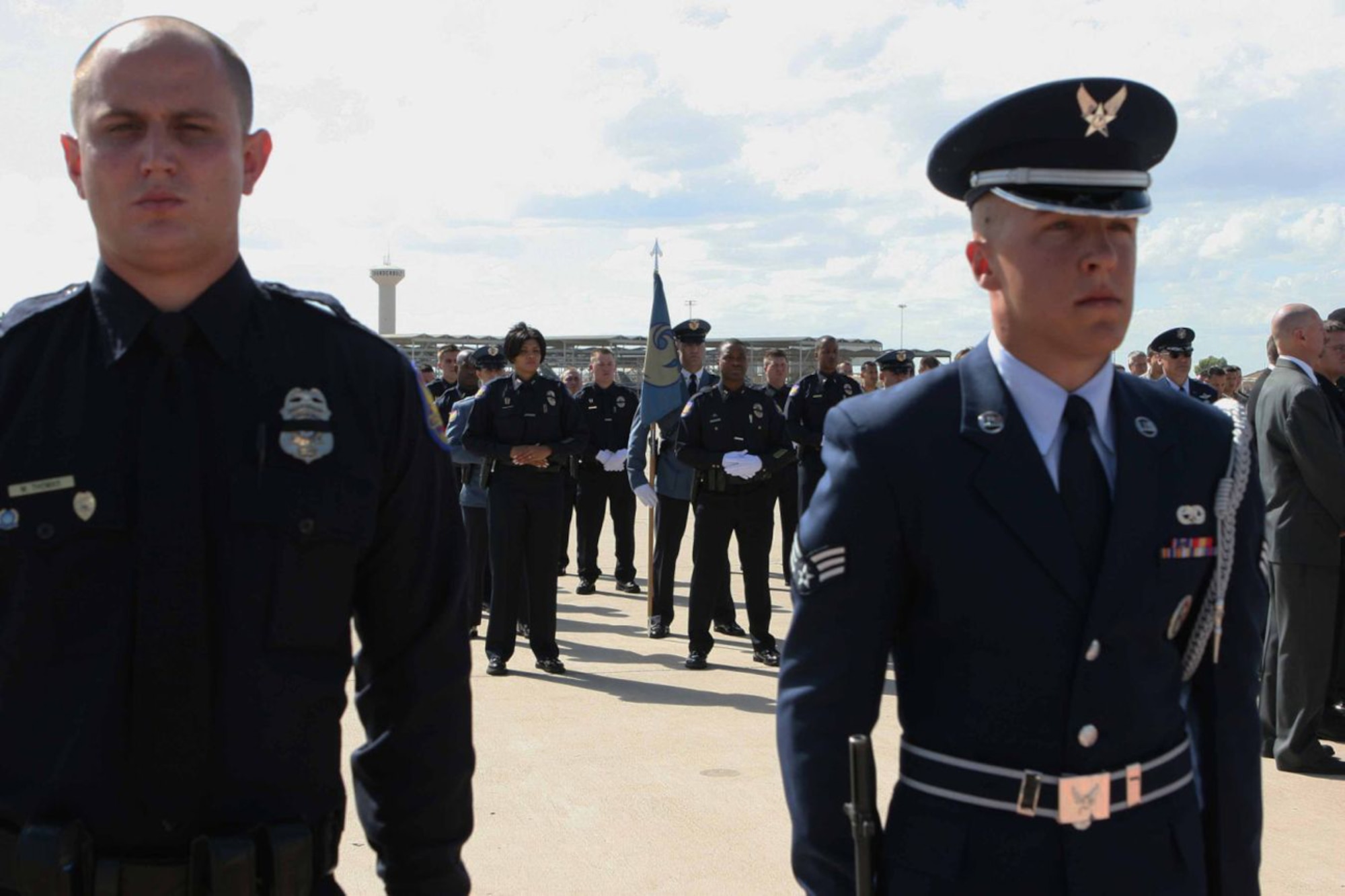 A Luke Air Force Base Honor Guard Airman stands in a cordon with a Phoenix police officer Oct. 12 on the base flight line prior to the arrival of Arizona Army National Guard Staff Sgt. Thomas Rabjohn.  (Phoenix PD/Courtesy Photo)
