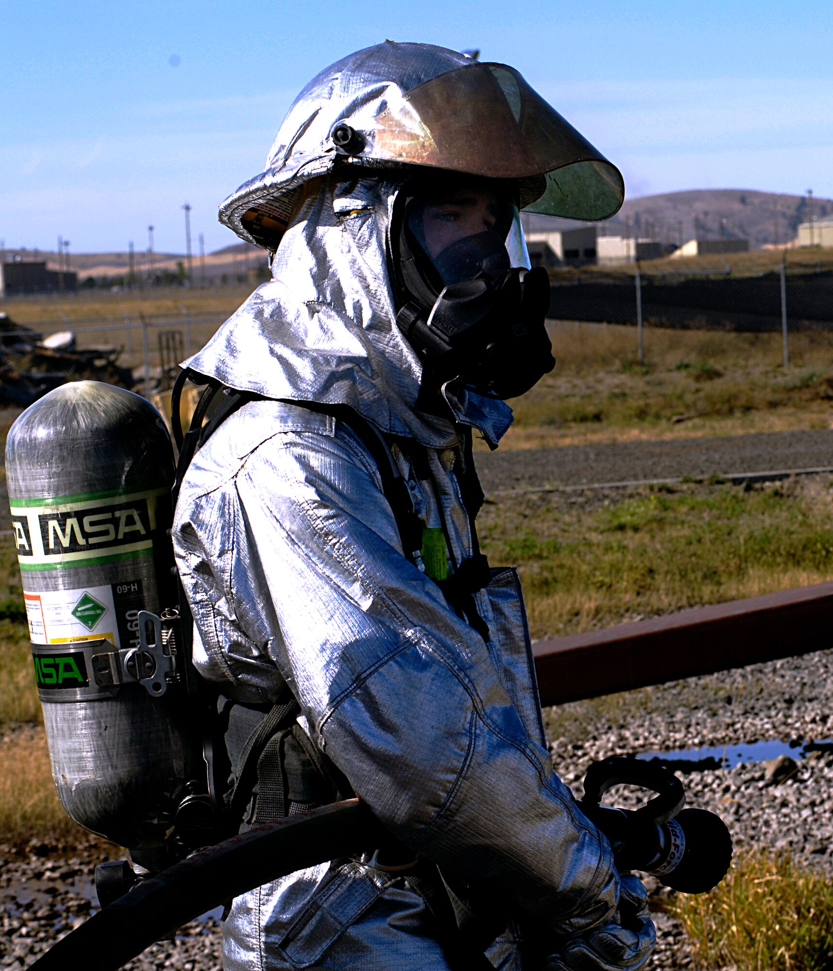 Airman 1st Class Jeremy Wilson, 92nd Civil Engineering Squadron fire fighter, prepares to hose down a mock aircraft here, which is set on fire internally and externally for training, Sept. 10. (U.S. Air Force photo/ Airman 1st Class Natasha E. Stannard)