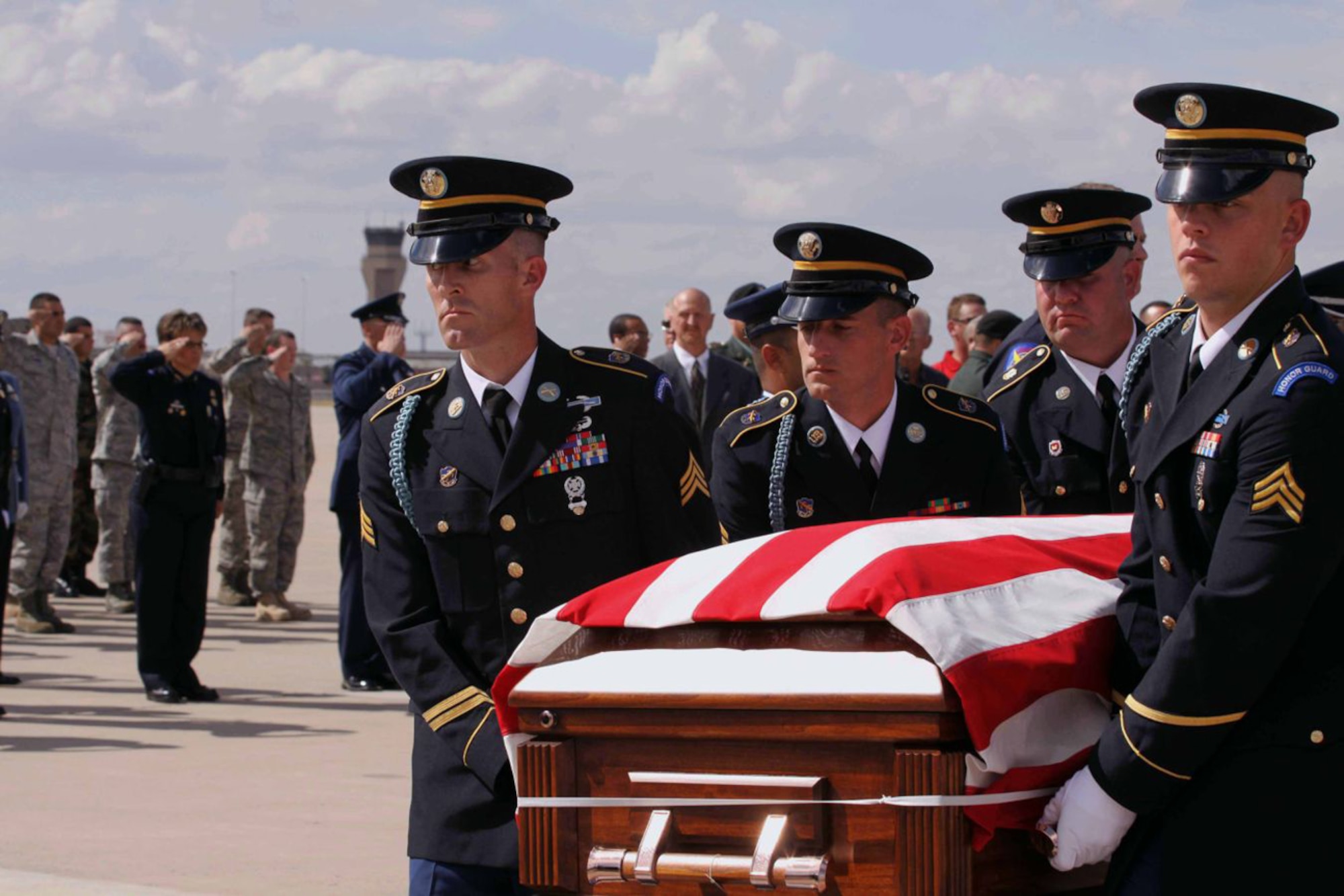An Army Honor Guard carries the casket of Arizona Army National Guard Staff Sgt. Thomas Rabjohn to a hearse as a formation of Luke Air Force Base Airmen and Phoenix Police Department officers salute on the base flightline Oct. 12.  Staff Sgt. Rabjohn was an Army explosive ordnance disposal technician and also a member of the Phoenix PD.  He was killed in Afghanistan while disarming an improvise explosive device.  (Courtesy Connie Tyler/Phoenix PD)