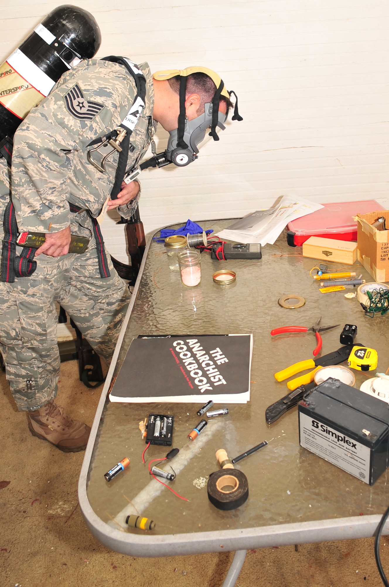 Tech. Sgt. Cecil McCrackin, 4th Civil Engineer Squadron explosive ordnance disposal journeyman, inspects a table of items after removing two simulated blocks of C-4 plastic explosives and blasting caps during exercise Orbit Comet in Goldsboro, N.C., Oct. 13. The exercise scenario simulated bomb identification and disposal requiring local authorities and Airmen from Seymour Johnson Air Force Base to work together in the Goldsboro community. (U.S. Air Force photo/Airman 1st Class Rae Perry)