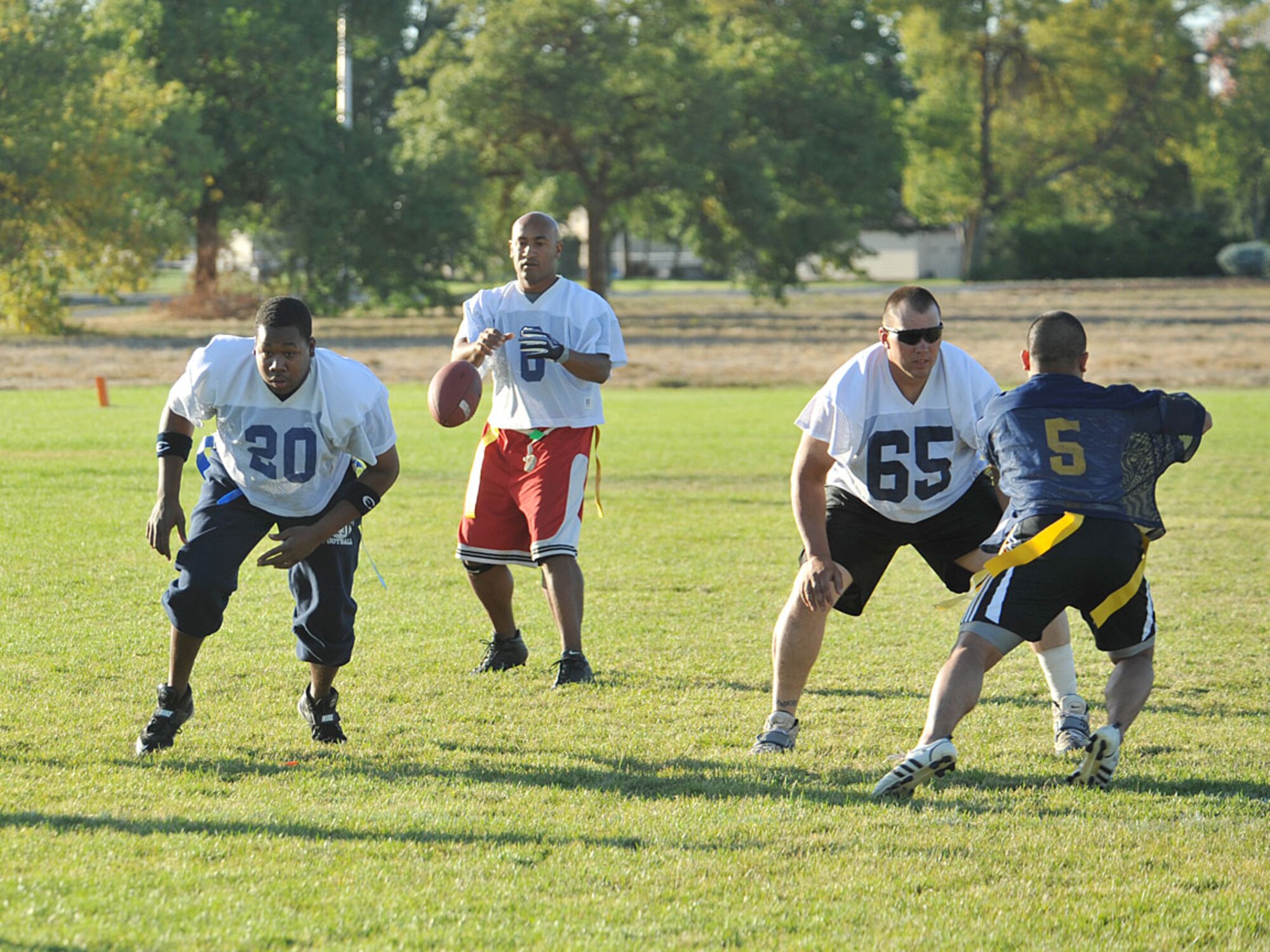 Staff Sgt.  James Gasaway, 92nd Civil Engineering Squadron fire fighter, prepares to receive snap from Airman First Class Antuan Hines , 92nd CES Heating Ventilation Air Conditioning/ Refrigeration apprentice during the championship flag football game Sept 26. The team beat the 92nd Medical Group 35 to 6 and solidified their goal in becoming base champions. The season was near perfect with 15 wins and one loss. (U.S. Air Force photo / Staff Sgt. JT May III)