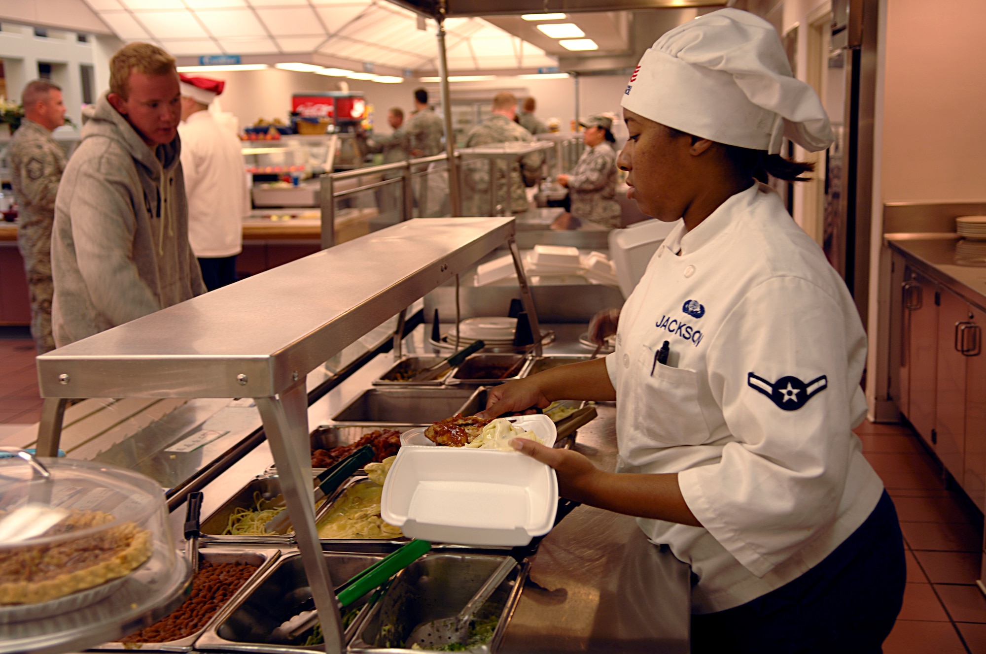 Airman 1st Class Tamekia Jackson, 92nd Force Support Squadron services chef, serves a patron at the Warrior dining facility here Sept. 22. Airman Jackson works morning shift at the dining facility in which she prepares breakfast, serves breakfast, and prepares and serves lunch. (U.S. Air Force photo/Airman 1st Class Natasha E. Stannard)