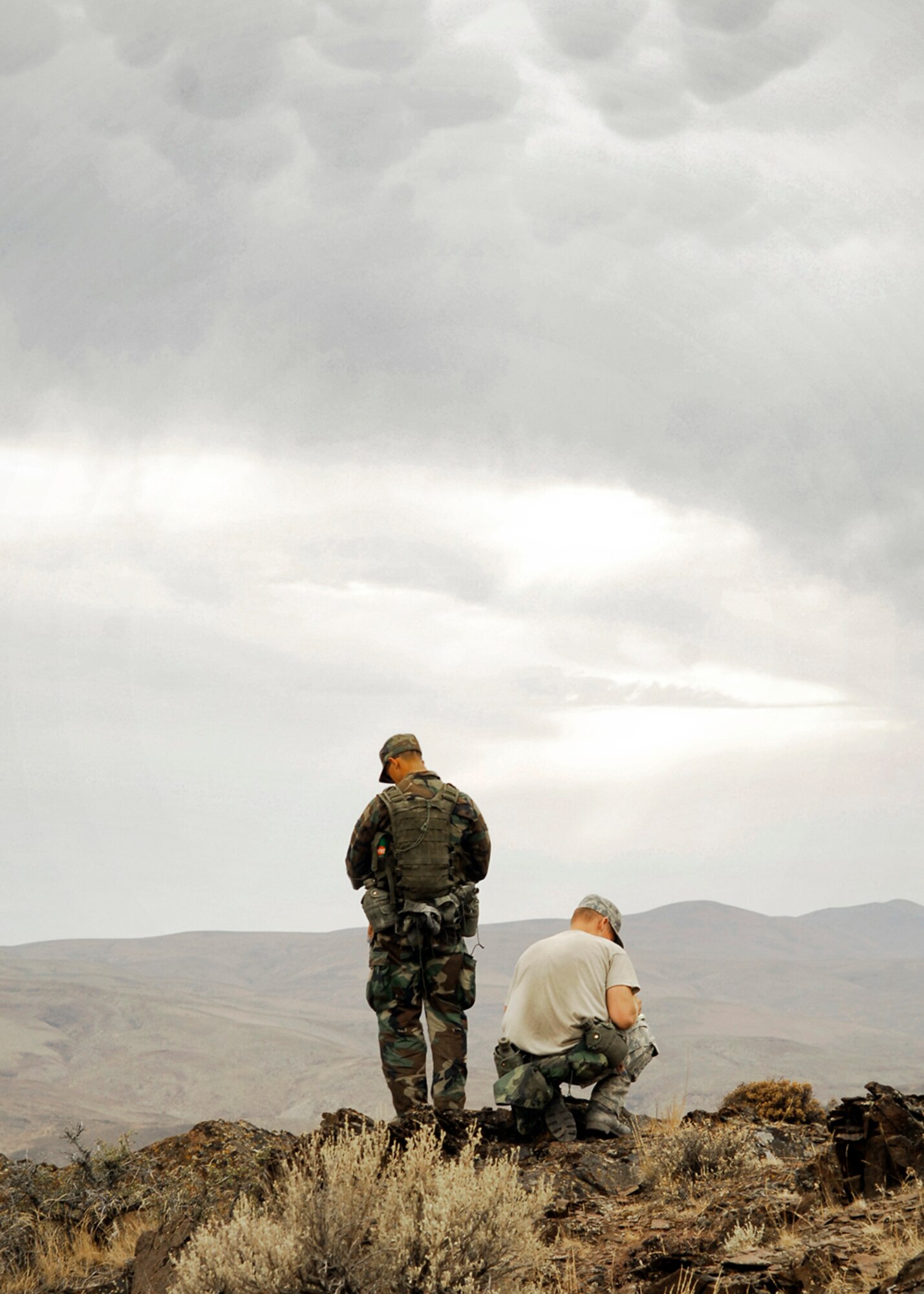 Two Survival, Evasion, Resistance, Escape technical school students stand dangerously close to a cliff edge that towers over the Columbia River here as they attempt to determine their position relative to map-marked landmarks. (U.S. Air Force photo / Senior Airman Joshua K. Chapman)