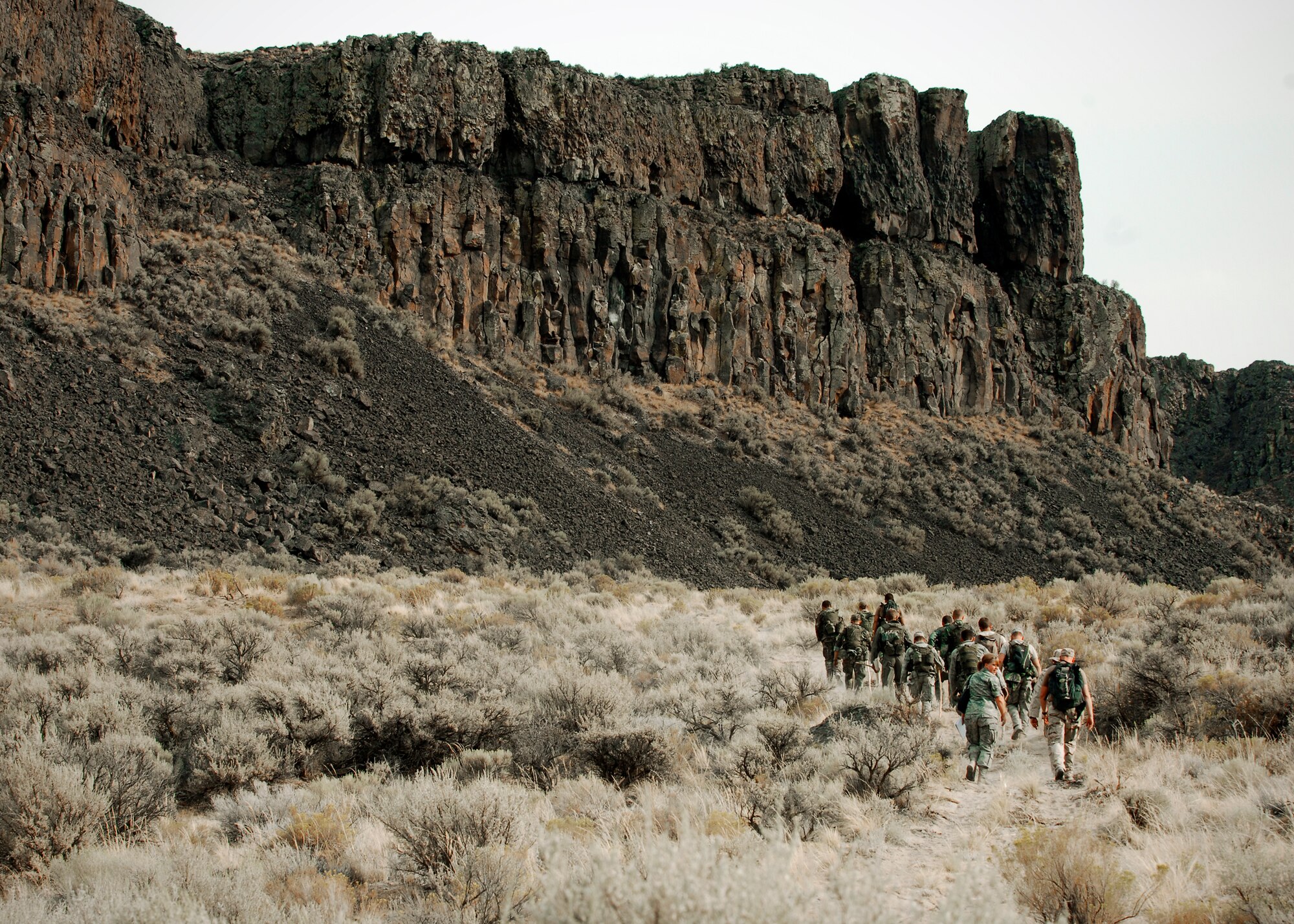 Survival, Evasion, Resistance and Escape specialists and technical school students head toward a cliff face as they search for a good starting point to begin climbing.(U.S. Air Force photo / Senior Airman Joshua K. Chapman) 