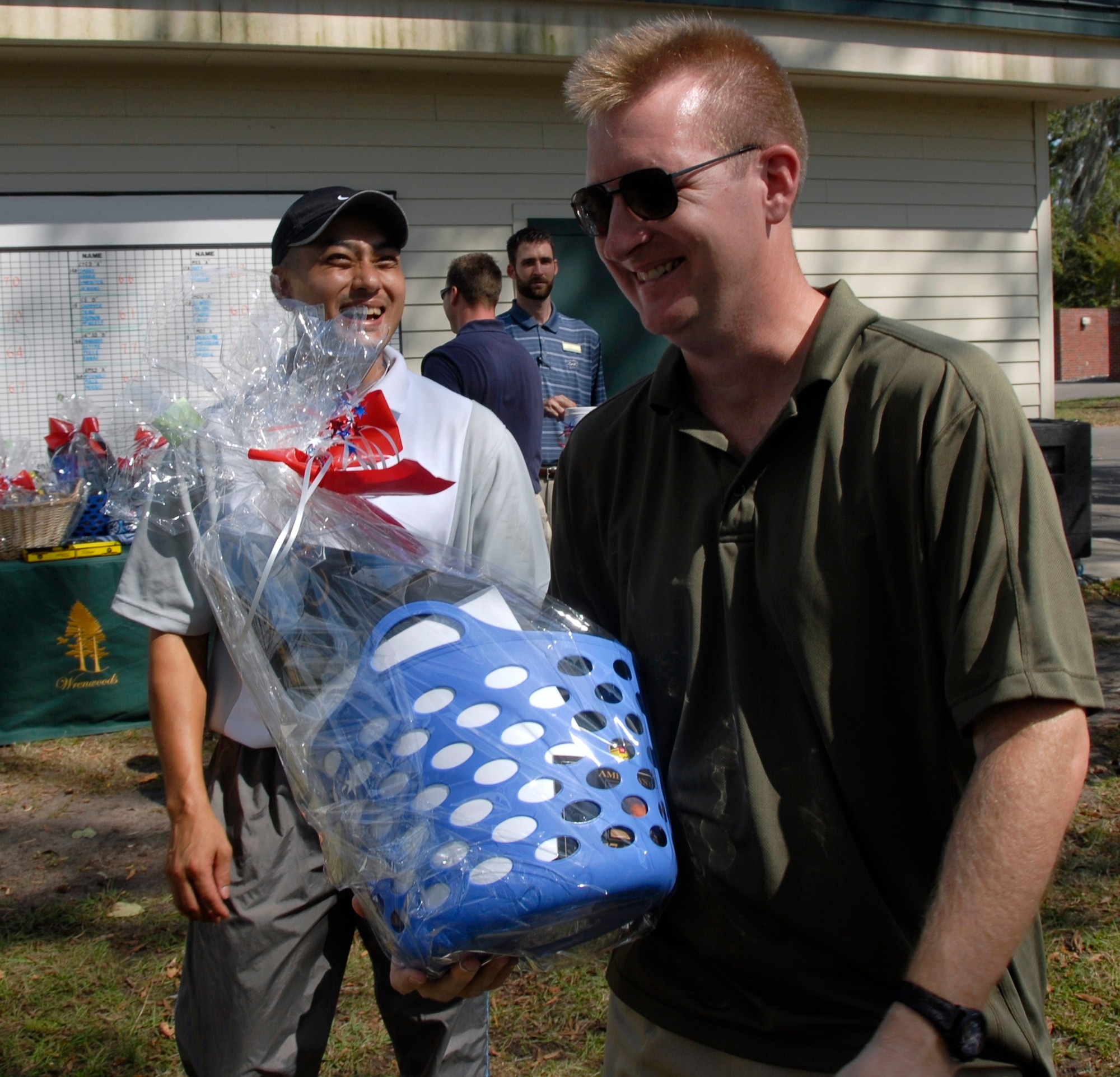 Lt. Col. Jim Donahue laughes with Lt. Col. Seung Paik after winning a gift basket during a raffle at the 437th Airlift Wing Golf Tournament at Wrenwoods Golf Course here Oct. 9. The gift baskets were put together for the raffle by members of the various Charleston AFB spouse clubs. Colonel Donahue is 437 AW chief of wing plans and Colonel Paik is the 437th Comptroller Squadron commander. (U.S. Air Force photo/Staff Sgt. Daniel Bowles)