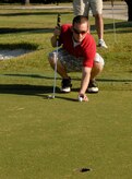 Airman 1st Class David Carlson places his golf ball on the green before putting during the 437th Airlift Wing Golf Tournament at Wrenwoods Golf Course here Oct. 9. Airman Carlson's putt put his team at three under par after five holes played. Airman Carlson is a crew chief with the 437th Maintenance Squadron. (U.S. Air Force photo/Staff Sgt. Daniel Bowles)