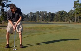 First Lt. John McDaniel lines up his putt during the 437th Airlift Wing Golf Tournament at Wrenwoods Golf Course here Oct. 9. The tournament included a commander's challenge portion and awarded the closest tee-shot to the pin and the longest drive. Lieutenant McDaniel is a pilot with the 15th Airlift Squadron. (U.S. Air Force photo/Staff Sgt. Daniel Bowles)