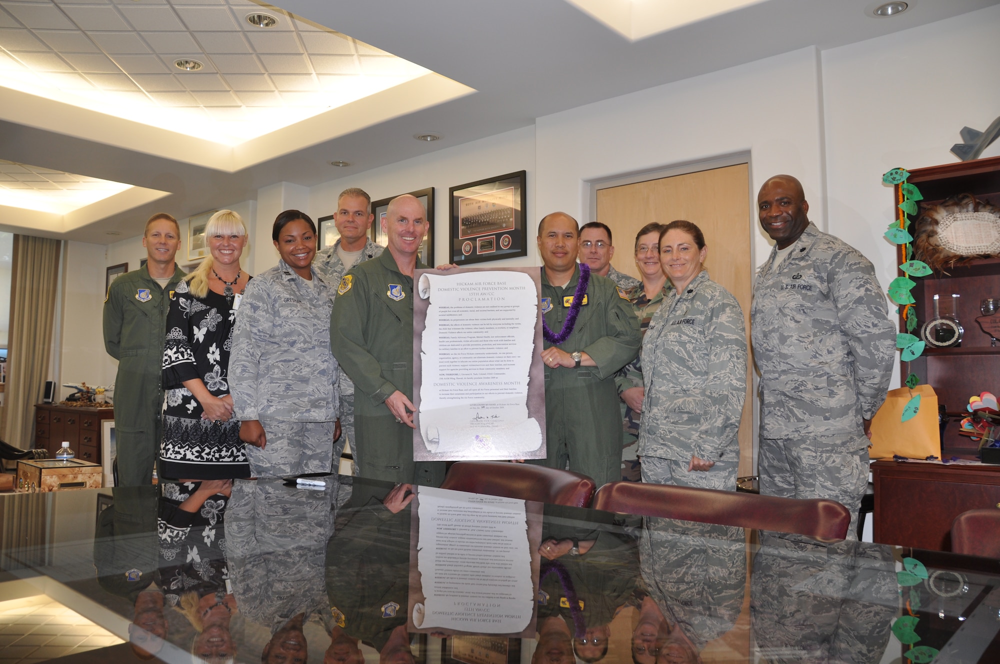HICKAM AIR FORCE BASE, Hawaii -- Col. Giovanni Tuck, 15th Airlift Wing commander, signed a proclamation Oct. 7 declaring his agreement with the appointment of October as Domestic Violence Awareness Month. Team Hickam leadership also showed their support by standing behind the colonel while he signed the document. The observance asks men and women alike to commit to ending violence within our homes, our communities, and our country. "Violence" is a broad term used to encompass sexual assault and date rape, dating violence, domestic violence and sexual harassment. (U.S. Air Force photo/Staff Sgt Carolyn Viss) 
