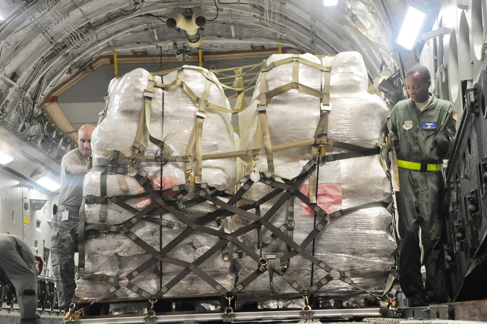 Airmen from McChord Air Force Base, Wash., and Hickam AFB, Hawaii, and Air Mobility Command civilians offload Federal Emergency Management Agency cargo from a C-17 Globemaster III Oct. 10, 2009, at Pago Pago International Airport, American Samoa. (U.S. Air Force photo/Staff Sgt. Eric Burks) 
