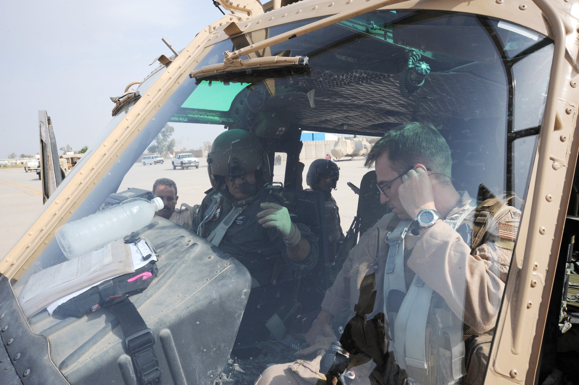 Maj. Jack Swinehart (right), 721st Air Expeditionary Advisory Squadron UH-1H pilot, observes an Iraqi pilot performing preflight procedures here prior to a helicopter training mission Oct. 8, 2009. The major sits side-by-side with Iraqi pilots as they practice approaches, take-offs, landings and aerial maneuver formation flying procedures. U.S. Air Force instructor pilots assigned to the 721st AEAS train, advise and assist Iraqi helicopter pilots around the clock, helping the Iraqis develop their own air force. Major Swinehart is deployed from and a native of Fort Rucker, Ala. (U.S. Air Force photo/Tech. Sgt. Johnny L. Saldivar) 

