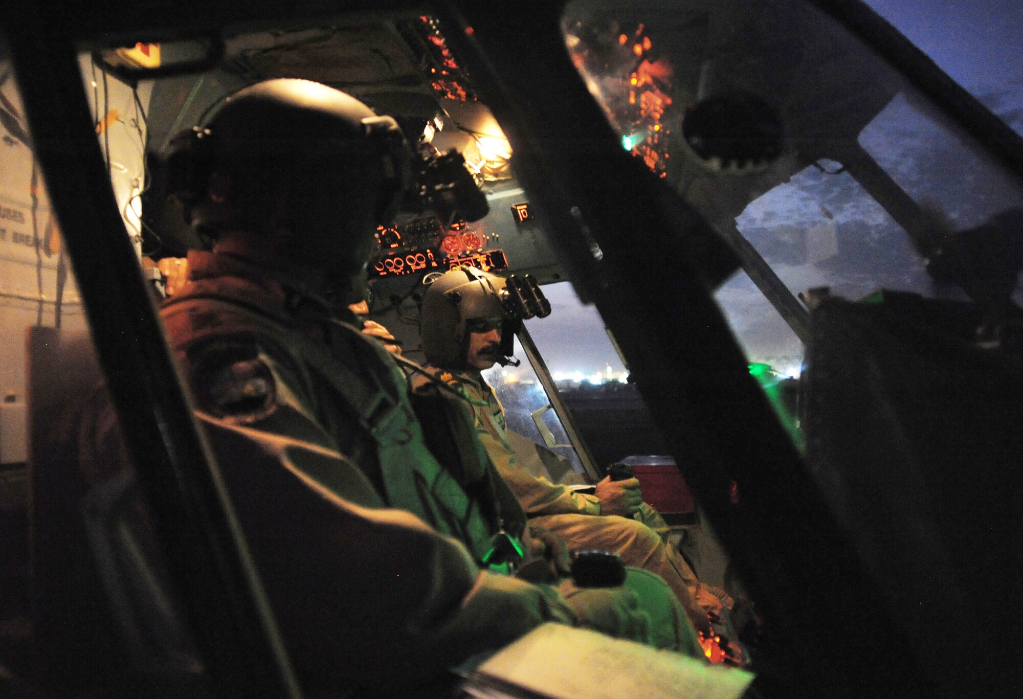 Maj. Christopher Elam (left) observes an Iraqi air force pilot performing preflight procedures here prior to a helicopter mission using night-vision goggles Oct. 7, 2009, at Camp Taji, Iraq. The major teaches them how to operate, preflight and maintain NVGs. U.S. Air Force instructor pilots assigned to the 721st Air Expeditionary Advisory Squadron train, advise and assist Iraqi helicopter pilots around the clock, helping them develop their own air force. Major Elam is a 721st AEAS Mi-17 pilot deployed from Kirtland Air Force Base, N.M. He hails from Evanston, Ill. (U.S. Air Force photo/Tech. Sgt. Johnny L. Saldivar