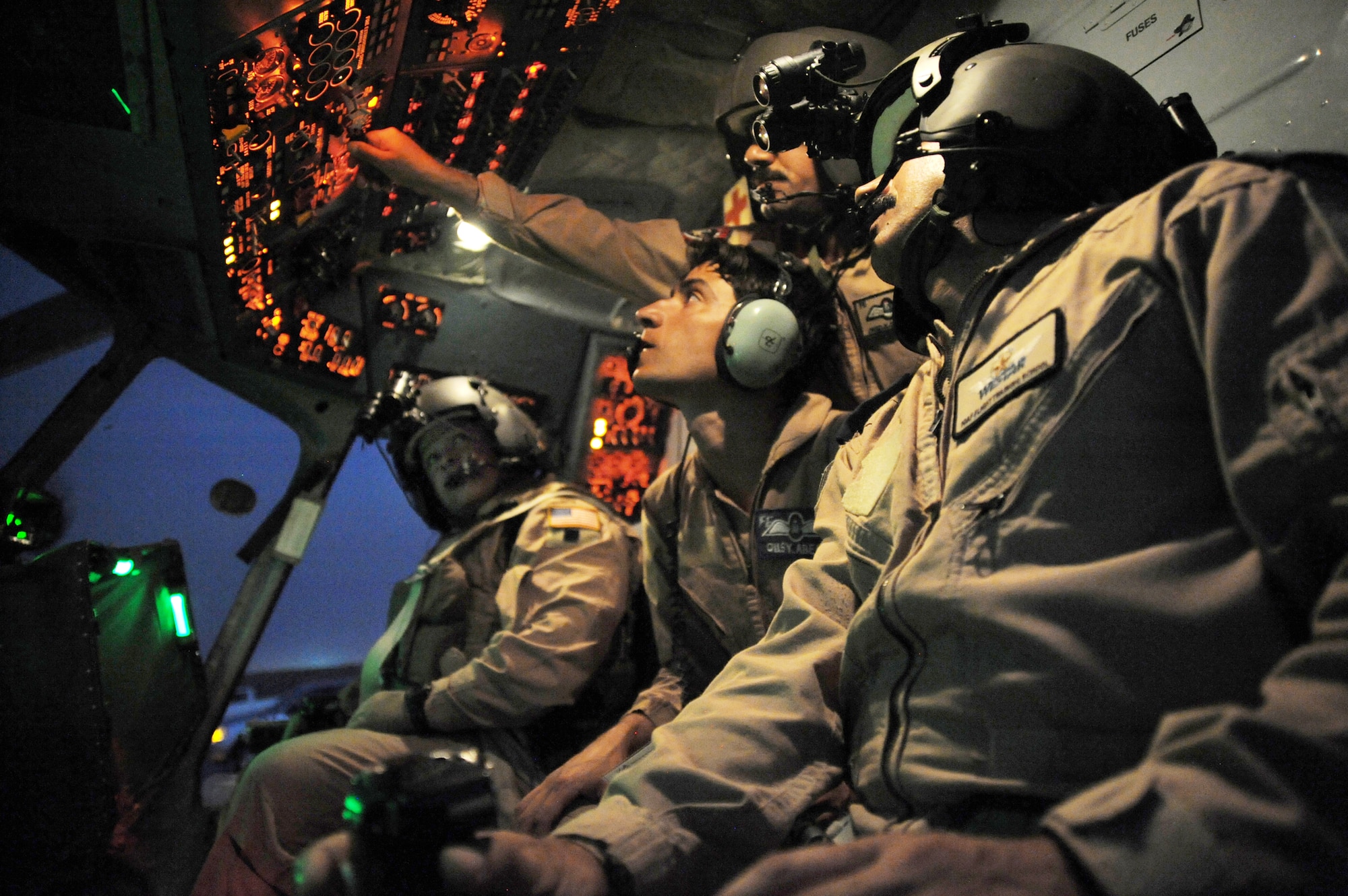 Maj. Christopher Elam (left) observes Iraqi air force pilots performing preflight procedures here prior to a helicopter mission using night-vision goggles Oct. 7, 2009, at Camp Taji, Iraq. The major teaches them how to operate, preflight and maintain NVGs. U.S. Air Force instructor pilots assigned to the 721st AEAS train, advise and assist Iraqi helicopter pilots around the clock, helping them develop their own air force. Major Elam is deployed from Kirtland Air Force Base, N.M., and hails from Evanston, Ill. (U.S. Air Force photo/Tech. Sgt. Johnny L. Saldivar) 