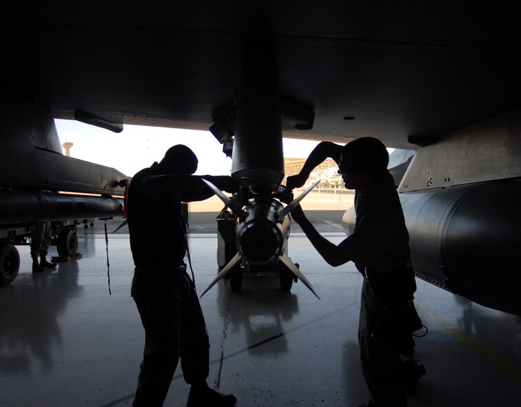 Members of the 61st Aircraft Maintenance Unit attach an MK-82 HD bomb during a Quarterly Weapons Load Crew Competition at Luke Air Force Base, October 9, 2009.  (U.S. Air Force photo by Airman 1st Class Sandra Welch)