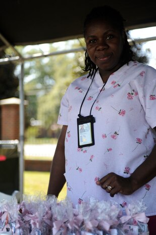 Patricia Grant sets up a booth for educating women on the dangers of breast cancer before the start of the Pink Heals Tour held here Oct. 9. The booth was set up as part of a Health Fair for the Pink Heals Tour. Ms. Grant is a nurse with the Navy. (U.S. Air Force photo/Senior Airman Amber Grimm)