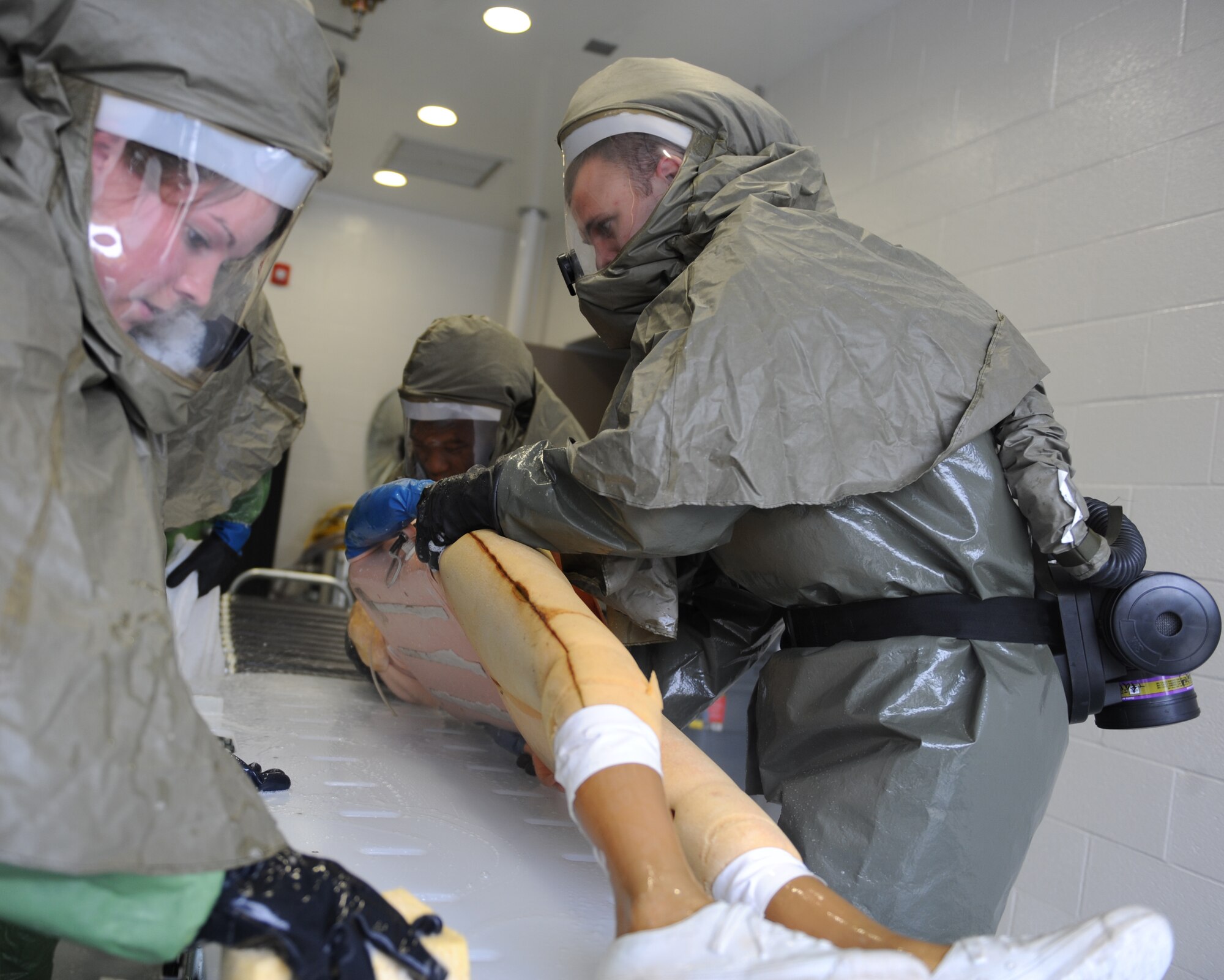 WHITEMAN AIR FORCE BASE, Mo. – Airman 1st class Jessica Jewett and Staff Sgt. Cory Philp, 509th Medical Operation Squadron, clean the back of a mannequin, during training, Oct. 13. The purpose of the training is to minimize the loss of operational capability caused by biological-related wartime contingencies and provide maximum protection for base personnel. (U.S. Air Force photo/Senior Airman Cory Todd)
