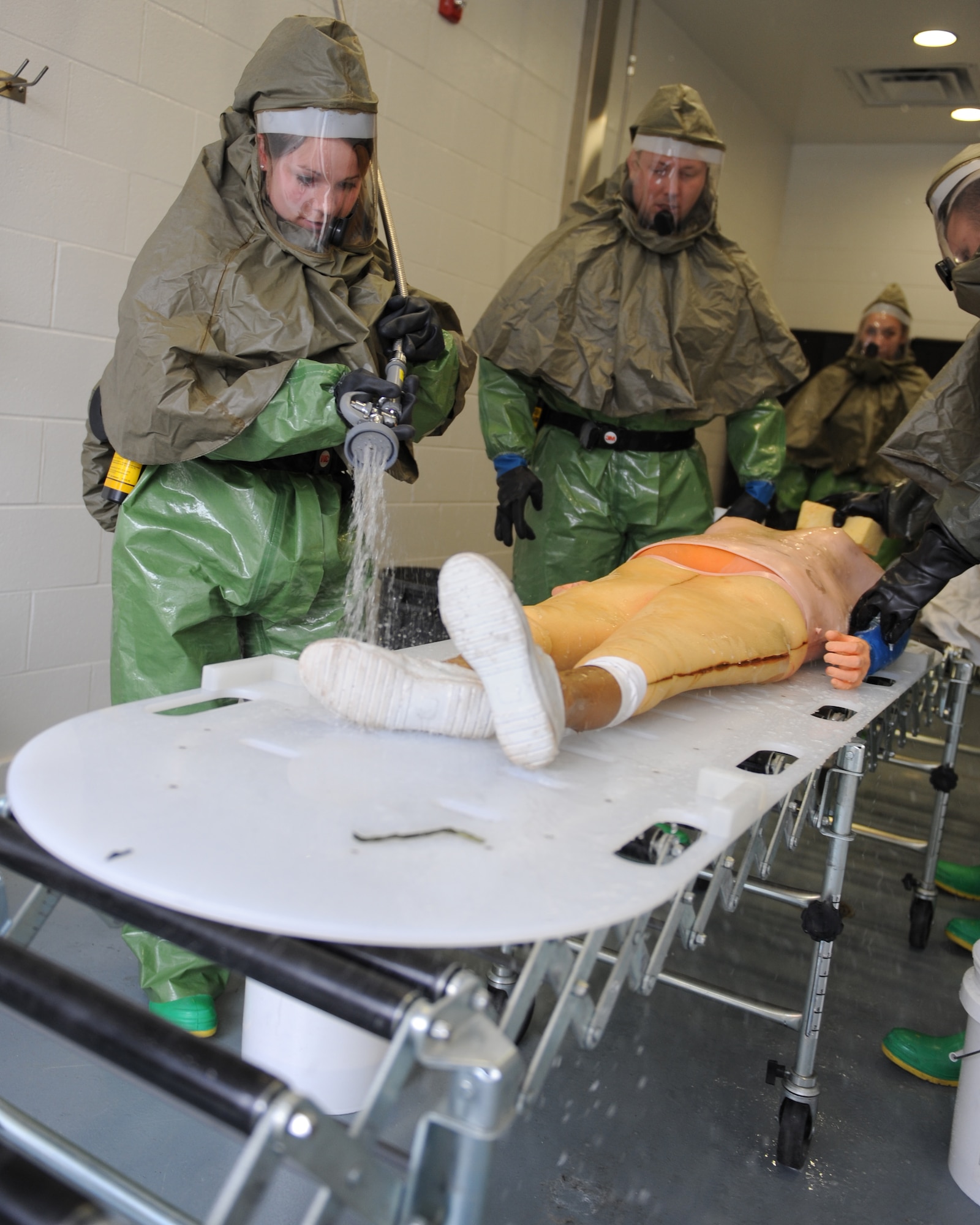 WHITEMAN AIR FORCE BASE, Mo. – Airman 1st Class Jessica Jewett, 509th Medical Operations Squadron, sprays the soap off of a mannequin, during training, Oct. 13. The purpose of the training is to minimize the loss of operational capability caused by biological-related wartime contingencies and provide maximum protection for base personnel. (U.S. Air Force photo/Senior Airman Cory Todd)