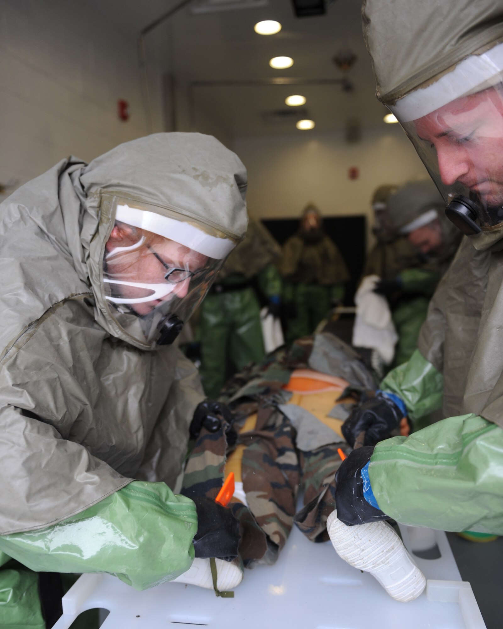 WHITEMAN AIR FORCE BASE, Mo. – Senior Airman Lynn Amoroso and Senior Airman Marcus Hawkins, 509th Medical Operations Squadron, cut the clothing from a mannequin, during training, Oct. 13. The purpose of the training is to minimize the loss of operational capability caused by biological-related wartime contingencies and provide maximum protection for base personnel. (U.S. Air Force photo/Senior Airman Cory Todd)