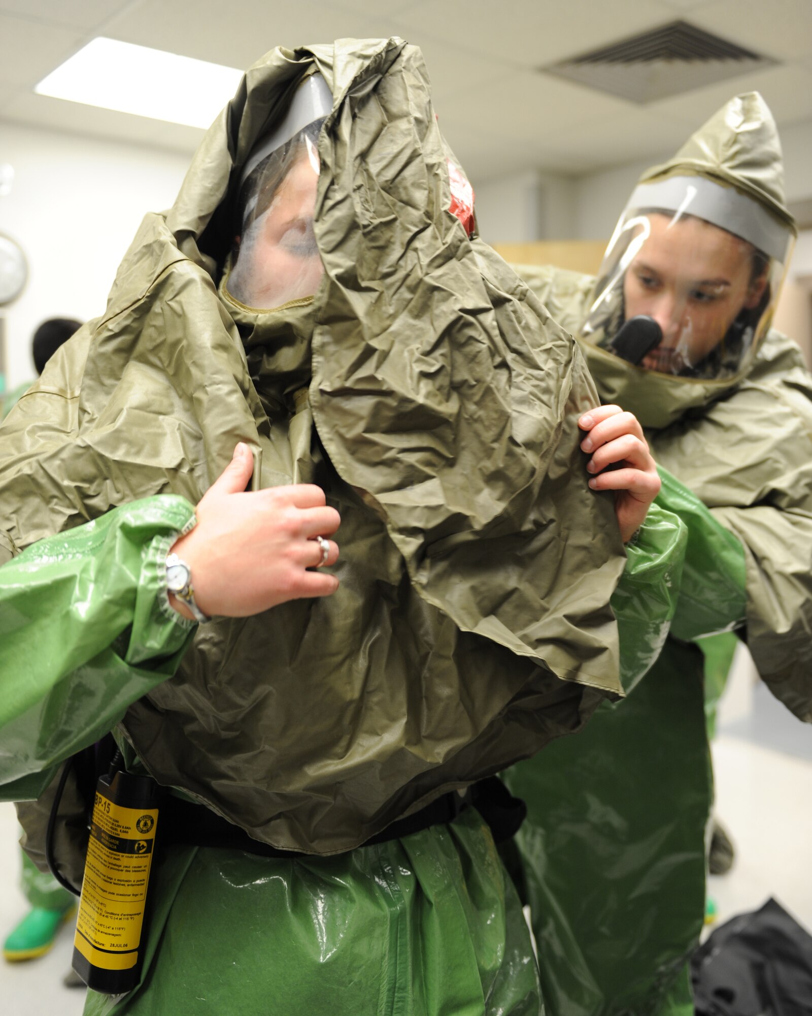 WHITEMAN AIR FORCE BASE, Mo. – Senior Airman Samantha Koch, 509th Medical Operations Squadron, aides Airman 1st Class Jessica Jewett, 509th MDOS, with putting on her chemical mask during training, Oct. 13. The purpose of the training is to minimize the loss of operational capability caused by biological-related wartime contingencies and provide maximum protection for base personnel. (U.S. Air Force photo/Senior Airman Cory Todd)