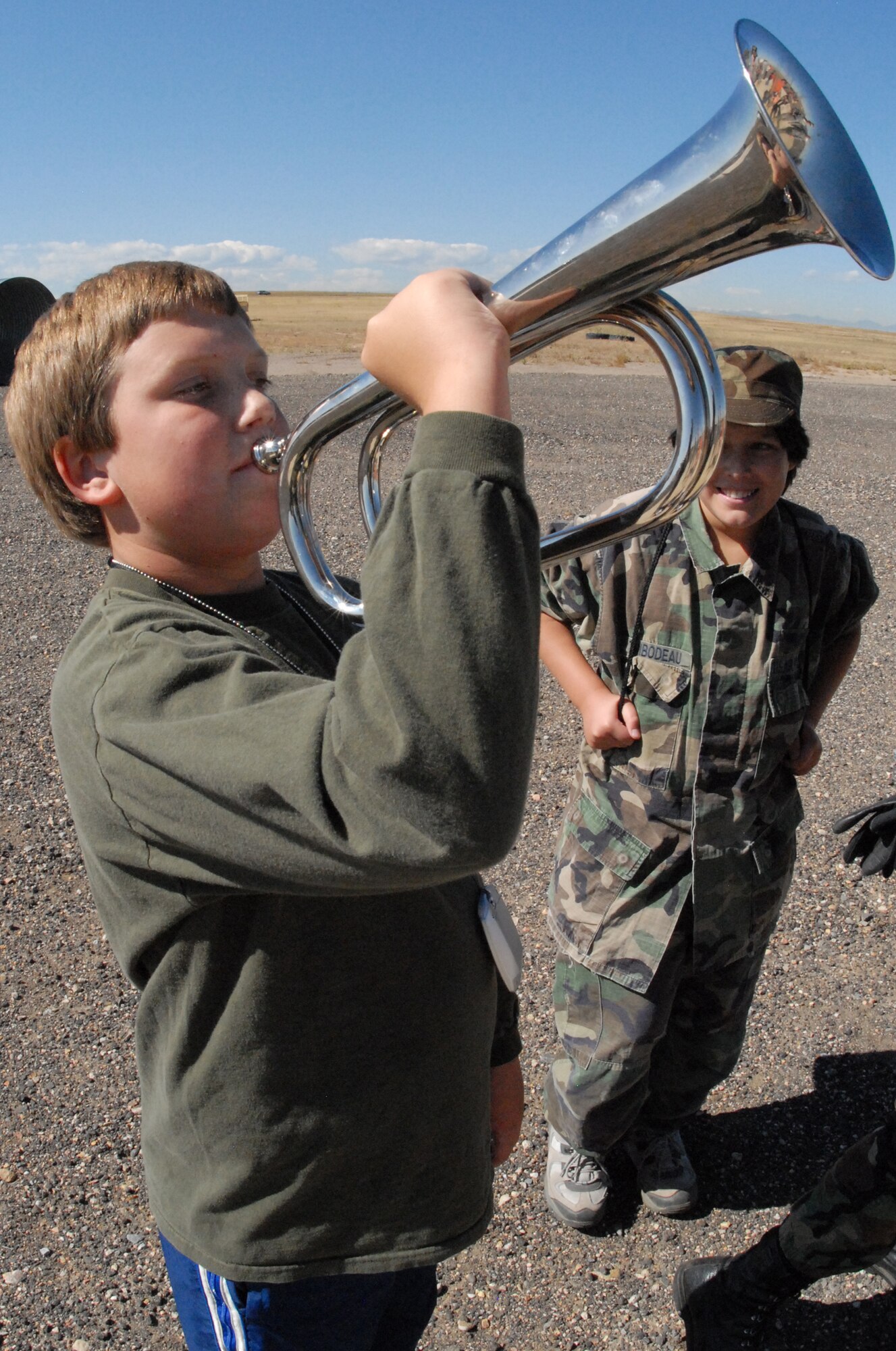 A youth mock deployment participant attempts to play reveille during a Mile High Honor Guard demonstration Oct. 3.  58 children from the Buckley Air Force Base community “deployed” as part of Buckley’s first “Year of the Air Force Family” event, a youth mock deployment.(U.S. Air Force photo by Tech. Sgt. J. LaVoie)