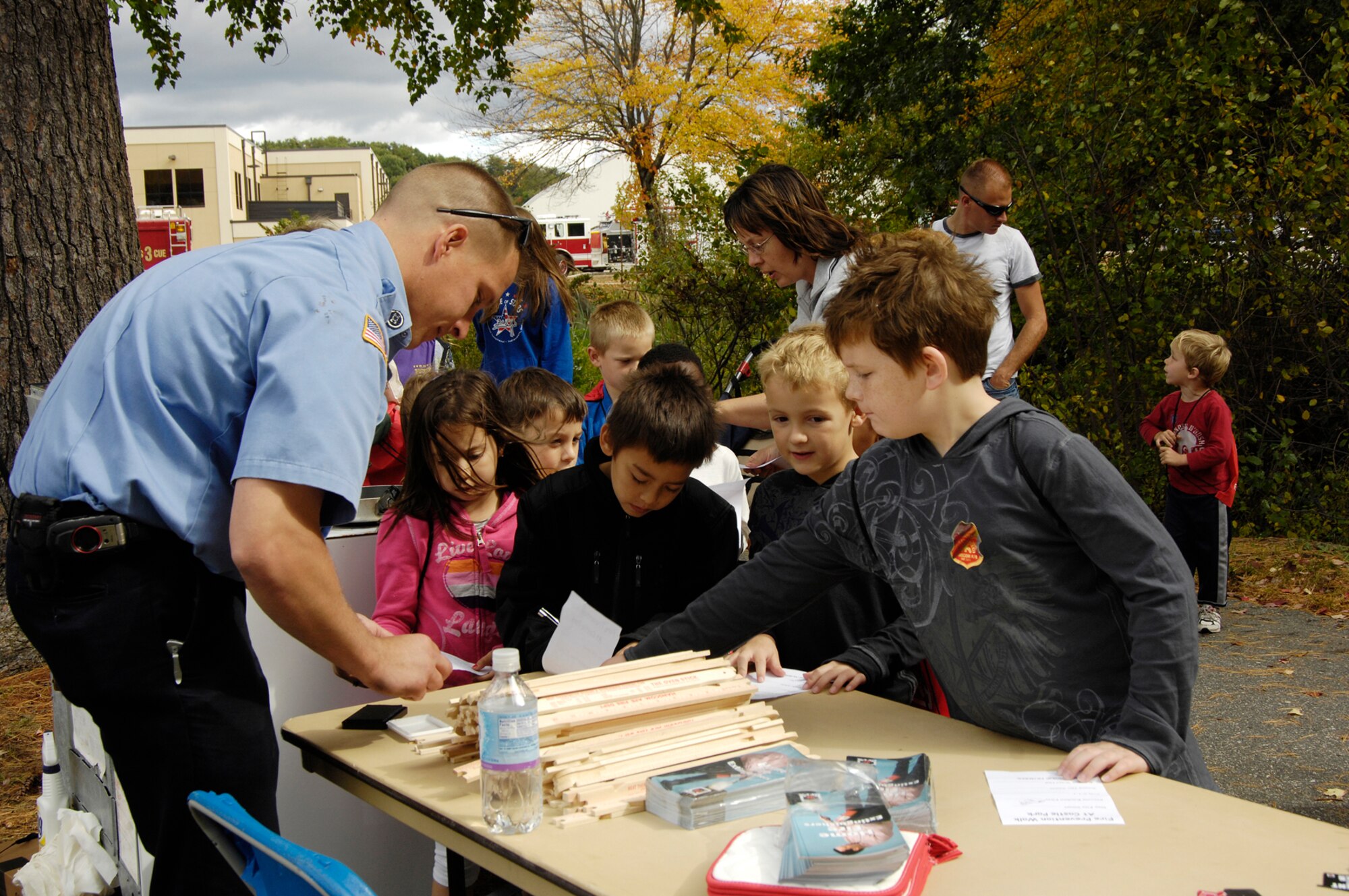 HANSCOM AIR FORCE BASE, Mass. – Firefighter Jerome Zuhoski, Hanscom Fire Department helps children with one of the fire safety activities at the Fire Prevention Walk at Castle Park on Oct. 10. The event wrapped up the base’s celebration of Fire Prevention Week and included several displays and activities to highlight to families the importance of fire safety.  (U.S. Air Force photo by Linda LaBonte Britt)