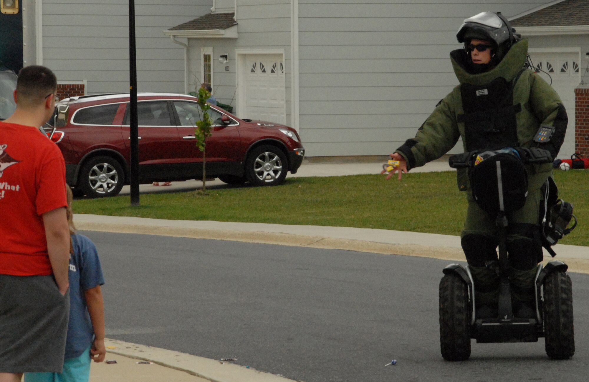 Airman 1st Class Allen Middaugh, 436th Civil Engineer Squadron Explosive Ordinance Disposal technician, tosses candy to base residents as he passes through base housing as part of the fire prevention parade.  The parade was held by the Dover Air Force Base Fire Station and off base agencies to conclude Fire Prevention Week Oct. 10. (U.S. Air Force photo by Staff Sgt. Chad Padgett)