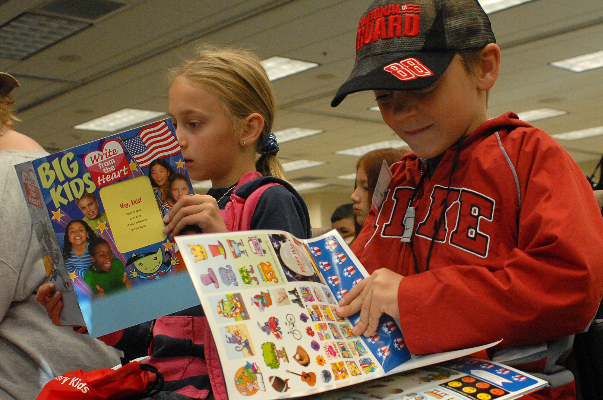 Michaela and Austin Gromer  check out the stickers and goodies they received in their “deployment” bags during the Buckley Air Force Base youth mock deployment, Oct 3.  Though the deployment was Buckley’s first “Year of the Air Force Family” event, it was truly joint as children from all four services, including active, guard and reserve, attended.  (U.S. Air Force photo by Tech. Sgt. J. LaVoie)