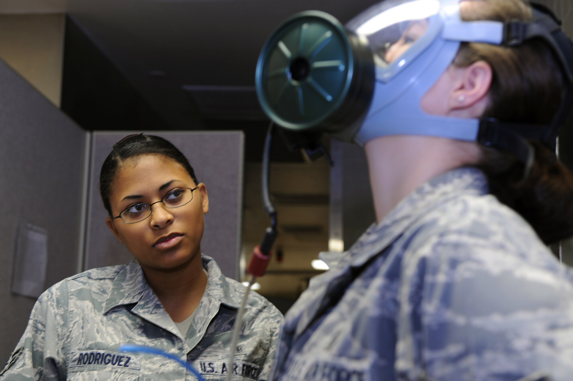 MINOT AIR FORCE BASE, N.D. -- Airman 1st Class Anjeolika Rodriguez, ensures a good seal on her coworker, Senior Airman Raven Motz, both 5th Medical Operations Squadron bioenvironmental engineer flight technicians, while training on a gas mask fit test here, Oct. 14.  Bioenvironmental engineers conduct respirator and gas mask fit tests in order to protect and maintain a healthy work force.  They also perform environmental, occupational and radiological surveillance, and serve as mission enhancers during emergency management response operations. (U.S. Air Force photo by Tech. Sgt. Lee A. Osberry Jr.)