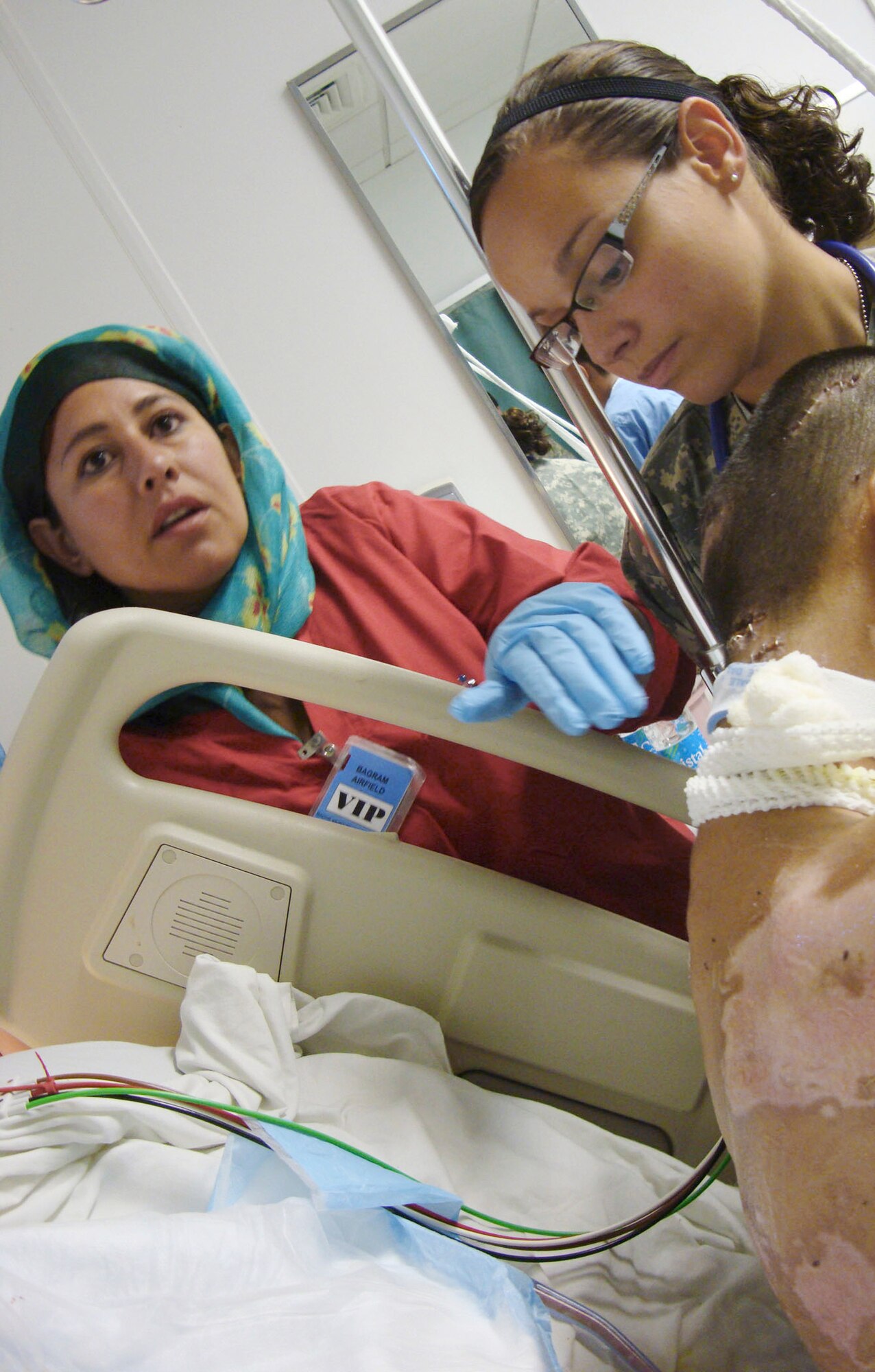 Afghan National Army soldier Laila Farahi (left) assists 1st. Lt. Nicole Pries with a patient Oct. 14, 2009, at Bagram Airfield, Afghanistan. Lieutenant Pries is an intensive care ward nurse deployed from the David Grant Medical Center at Travis Air Force Base, Calif. (Courtesy photo) 