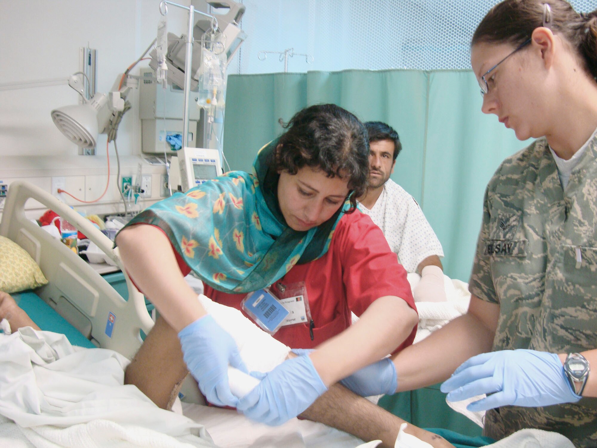 Afghan National Army soldier Laila Farahi (left) bandages a patient's leg Oct. 14, 2009, at Bagram Airfield, Afghanistan. She attended a special two-week mentorship program at the Criag Joint Theater Hospital here to work alongside U.S. doctors and nurses to hone her medical skills and get firsthand experience with trauma-based care. She was one of the first women to ever attend the special program. (Courtesy photo) 